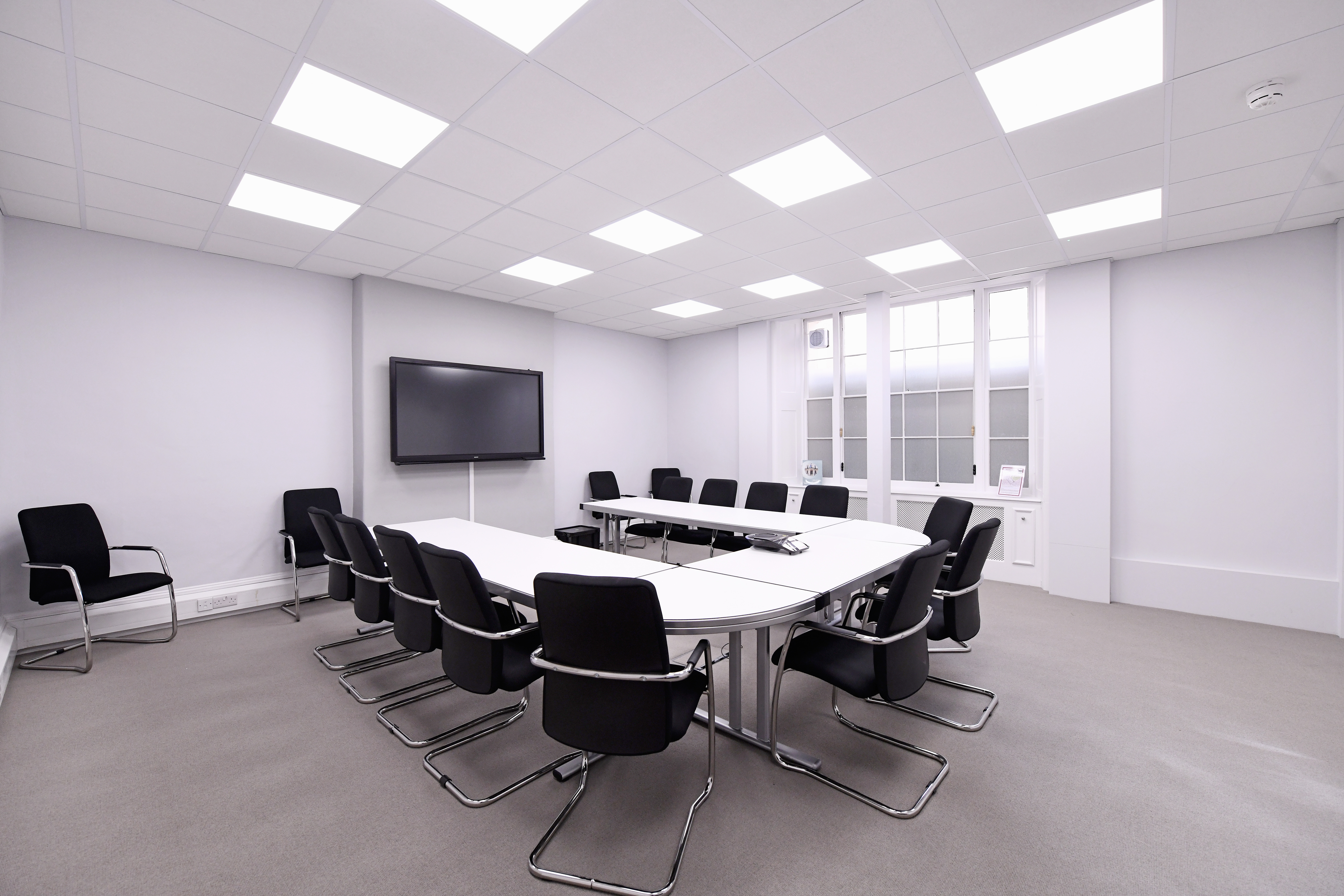 Modern conference room with oval table, ideal for corporate meetings and presentations.