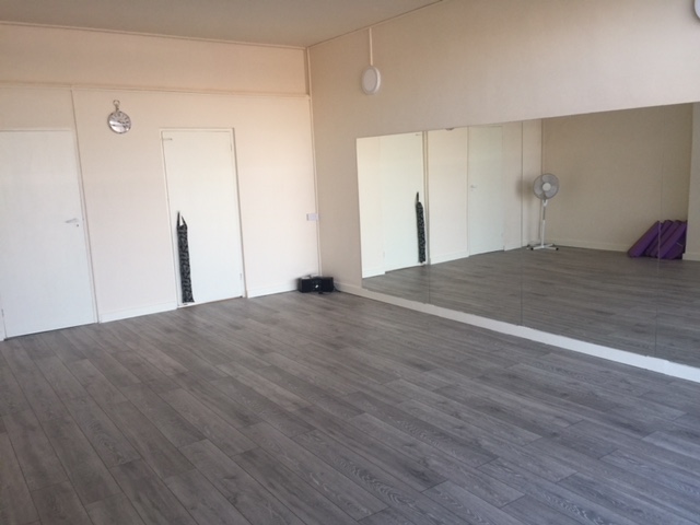 Versatile event space with large mirror, ideal for workshops and fitness classes.