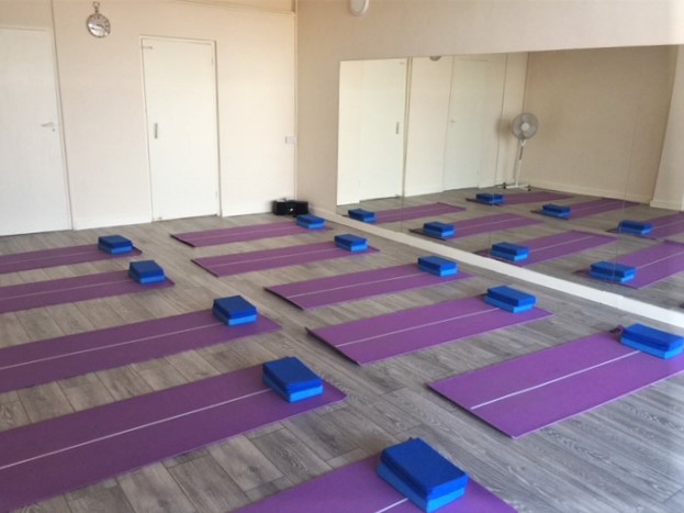 Yoga studio with purple mats, ideal for wellness retreats and corporate events.