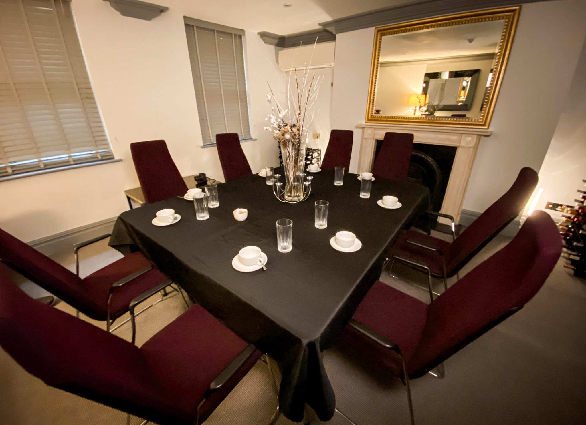 Fox Meeting Room at The Fox Club Mayfair with round table and maroon chairs for events.