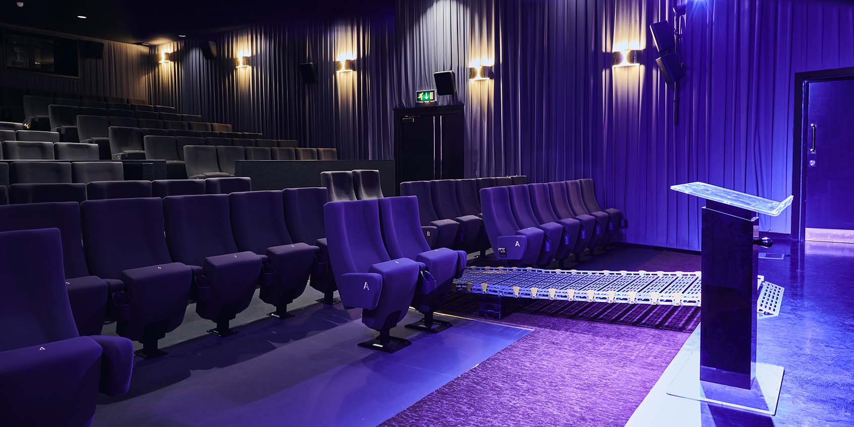 Modern auditorium with tiered seating at Barbican Centre for conferences and film screenings.