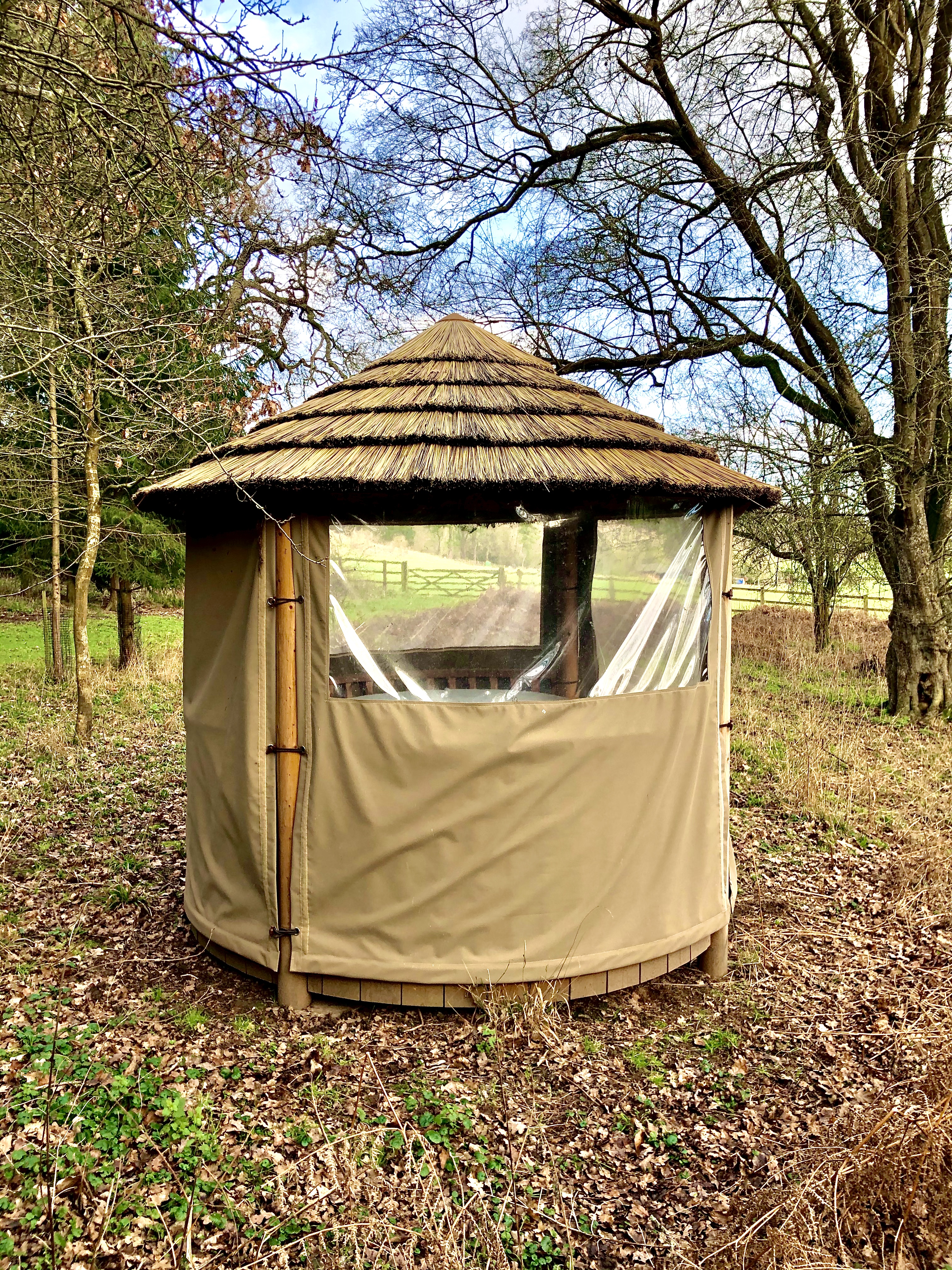 Woodland Lodge gazebo with thatched roof, perfect for outdoor retreats and gatherings.