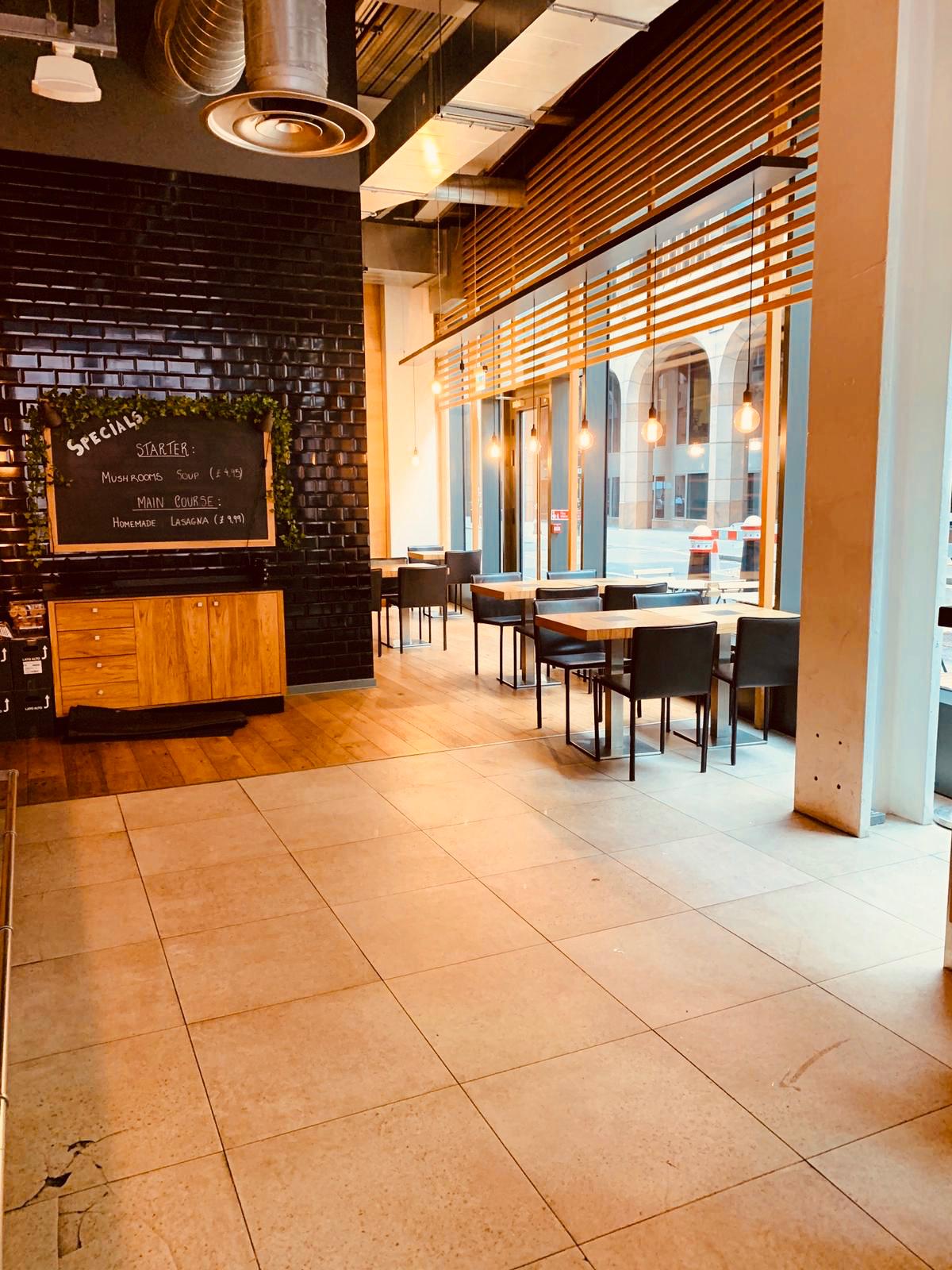 Modern event space with wooden tables, ideal for meetings and networking events.