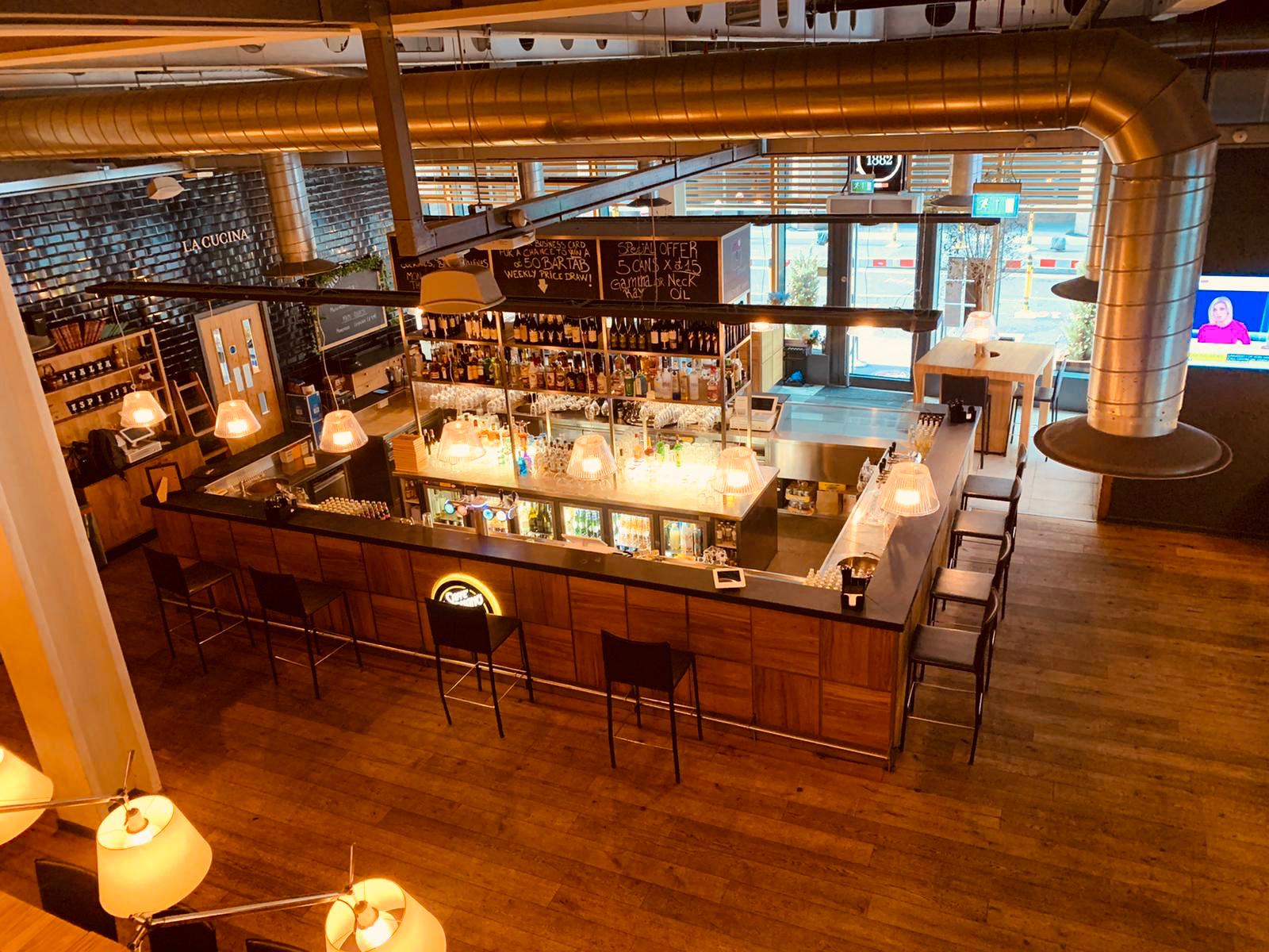 Modern bar venue with warm wood tones, ideal for networking events and gatherings.
