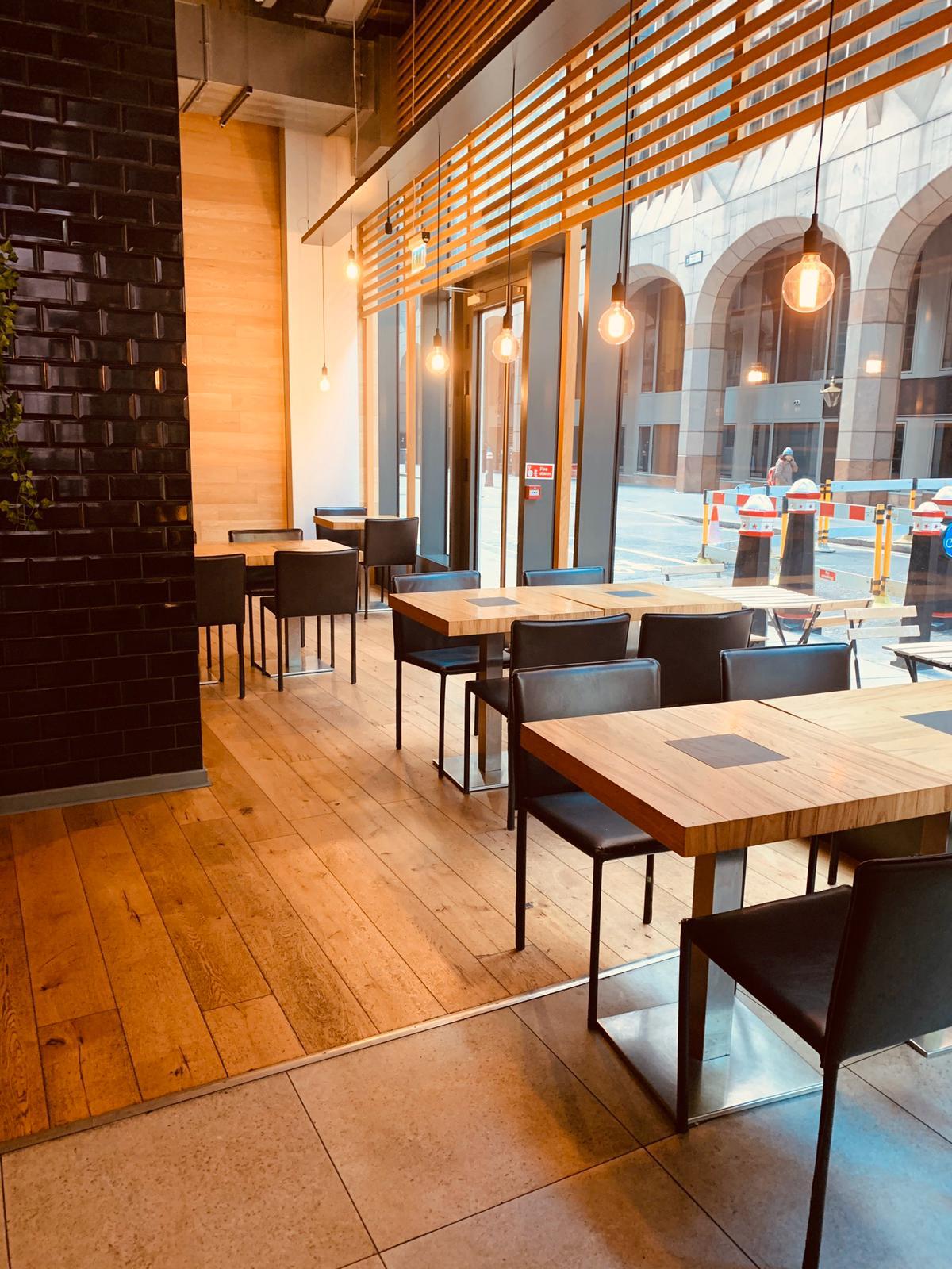 Modern venue with wooden tables, ideal for networking events and meetings.