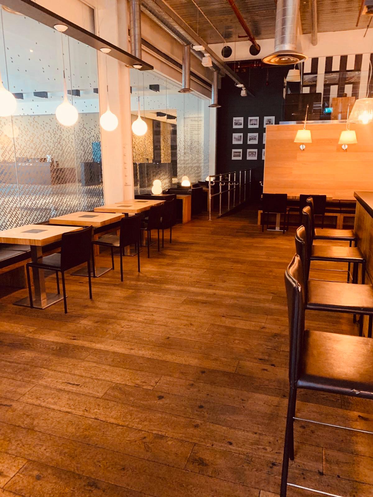 Modern venue with wooden flooring, ideal for meetings and networking events.