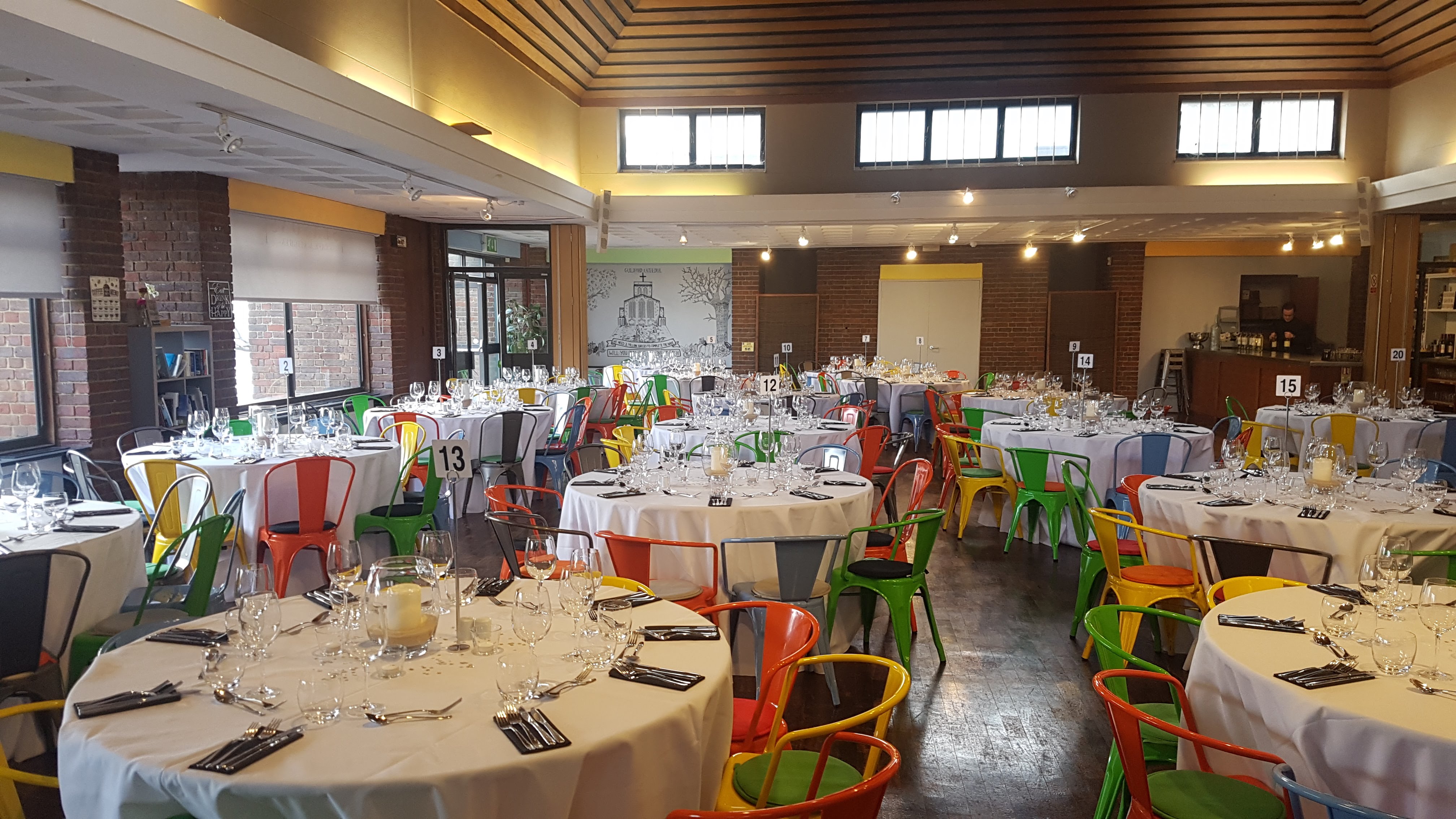 Guildford Cathedral banquet hall with round tables, elegant decor for events and celebrations.