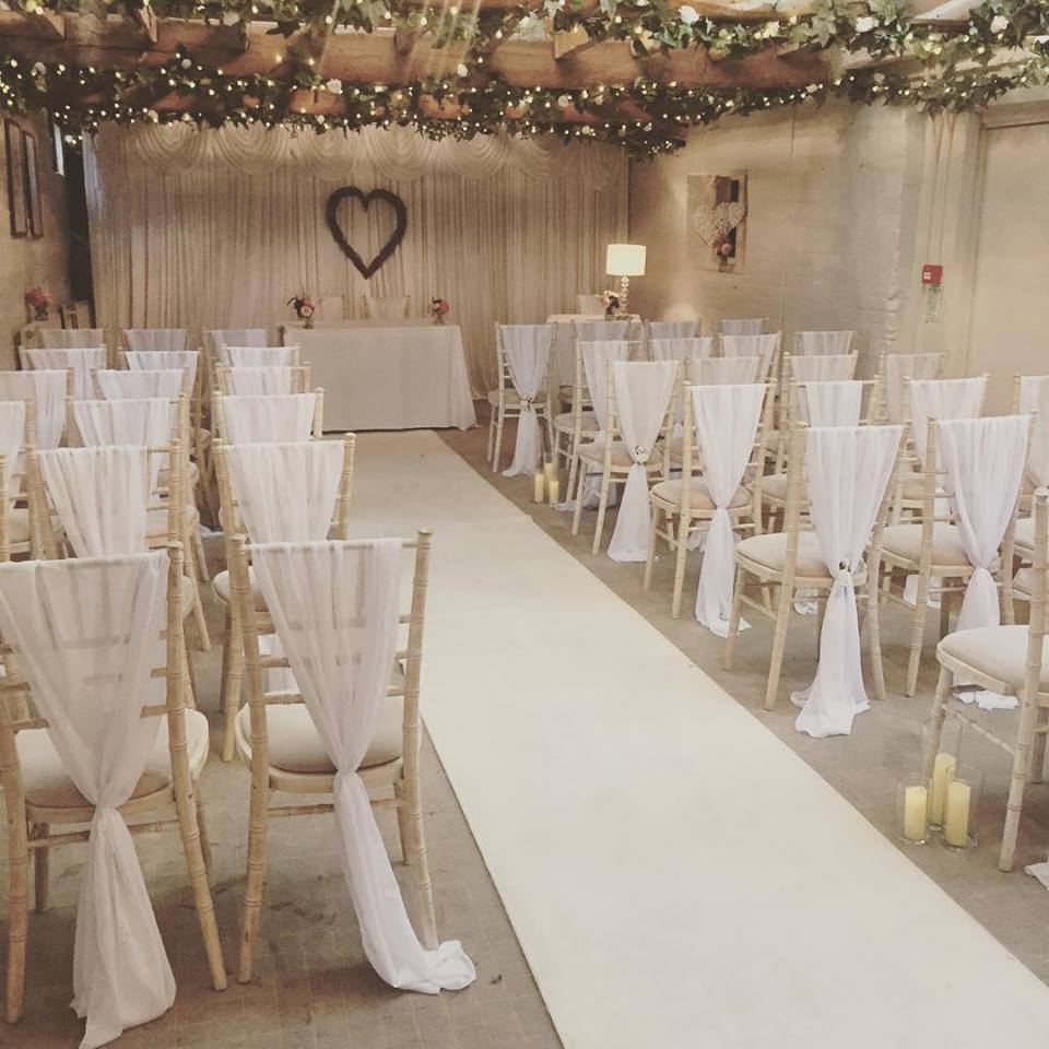 Elegant wedding ceremony space at The Surrey Barns with soft fabric-draped chairs.