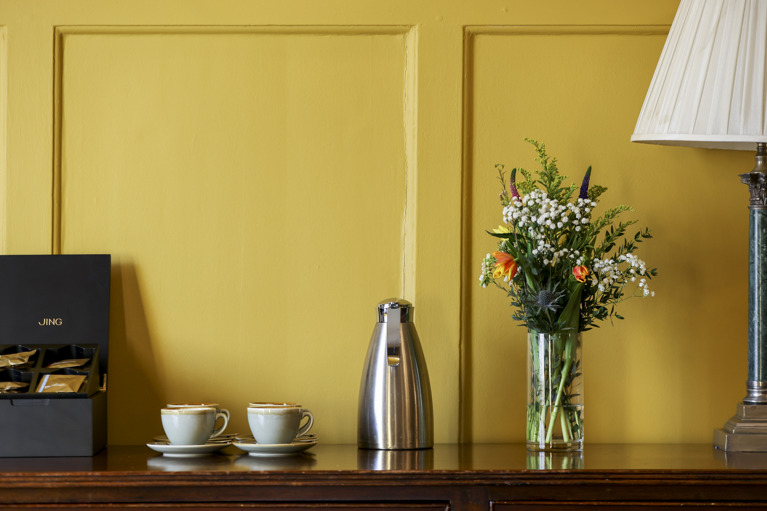 Refreshment station in The HAC Ante Room, vibrant yellow backdrop, ideal for meetings.