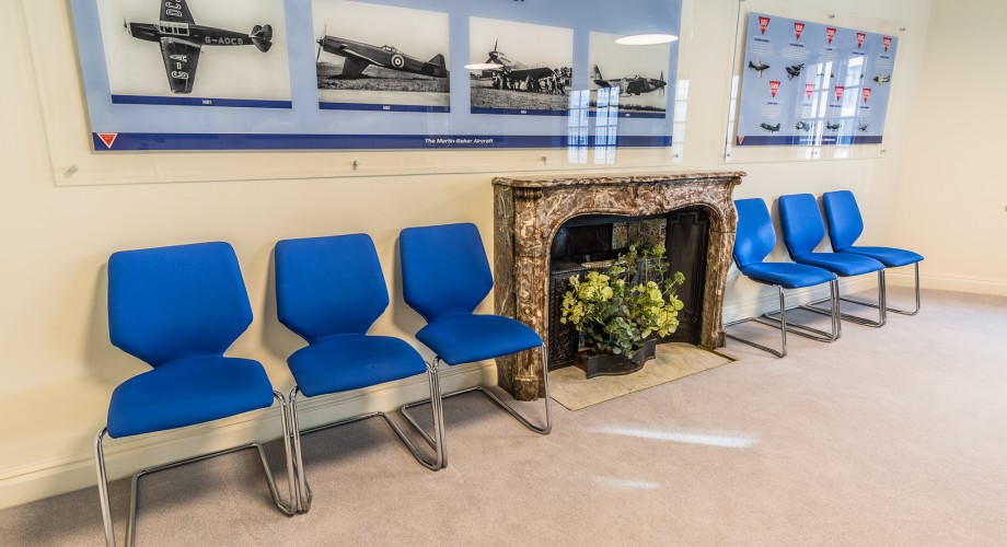 Martin-Baker Room with blue chairs and aviation art, perfect for meetings and events.