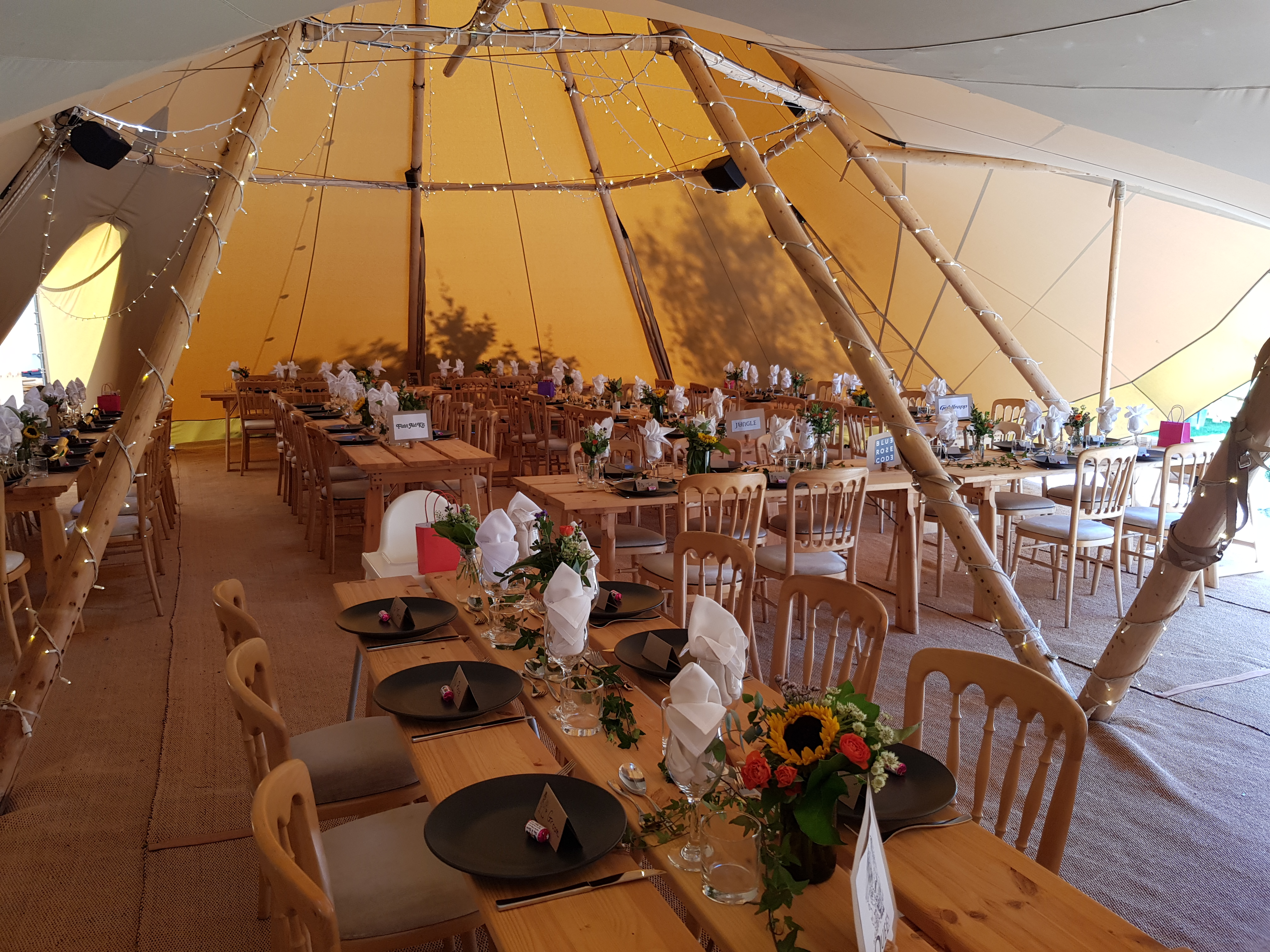 Woodlands Tipi at Blacknest Golf Club, elegant wedding venue with rustic decor and floral centerpieces.