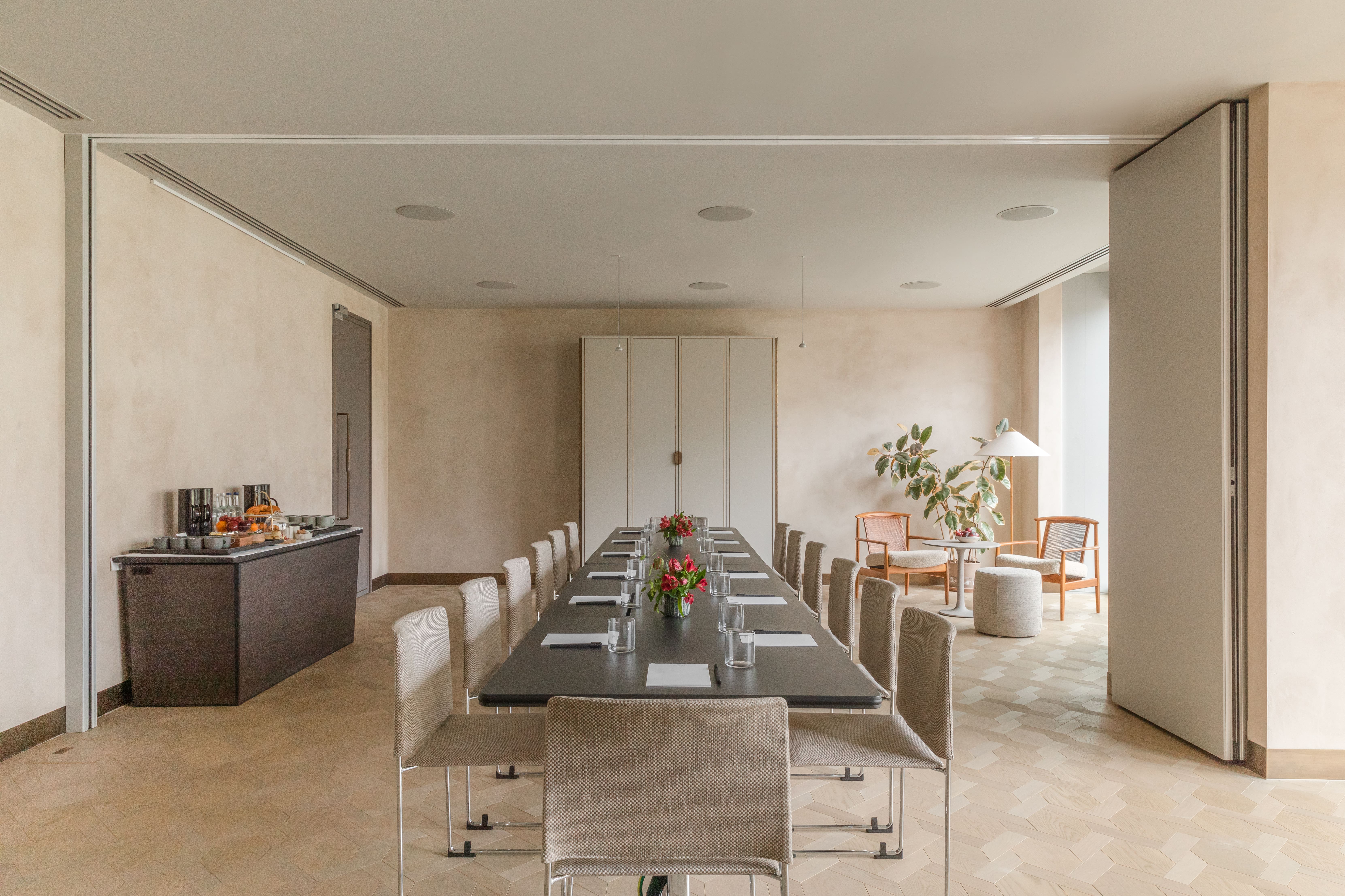 Modern meeting room with long table, ideal for professional gatherings and events.