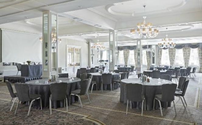 Ballroom at Richmond Hill Hotel with elegant round tables for corporate events and gatherings.