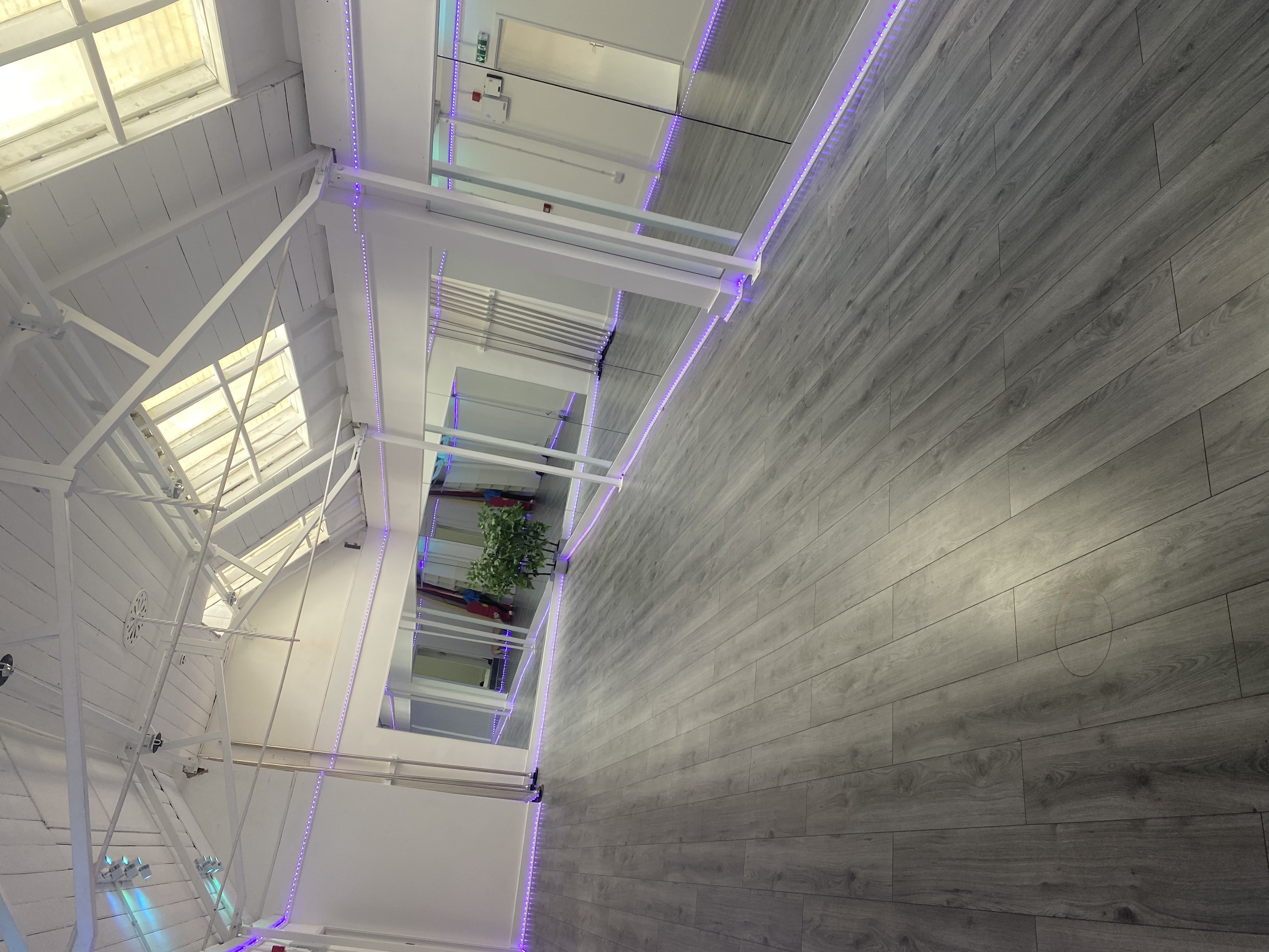 Versatile event space with modern flooring and mirrors, perfect for workshops and fitness classes.