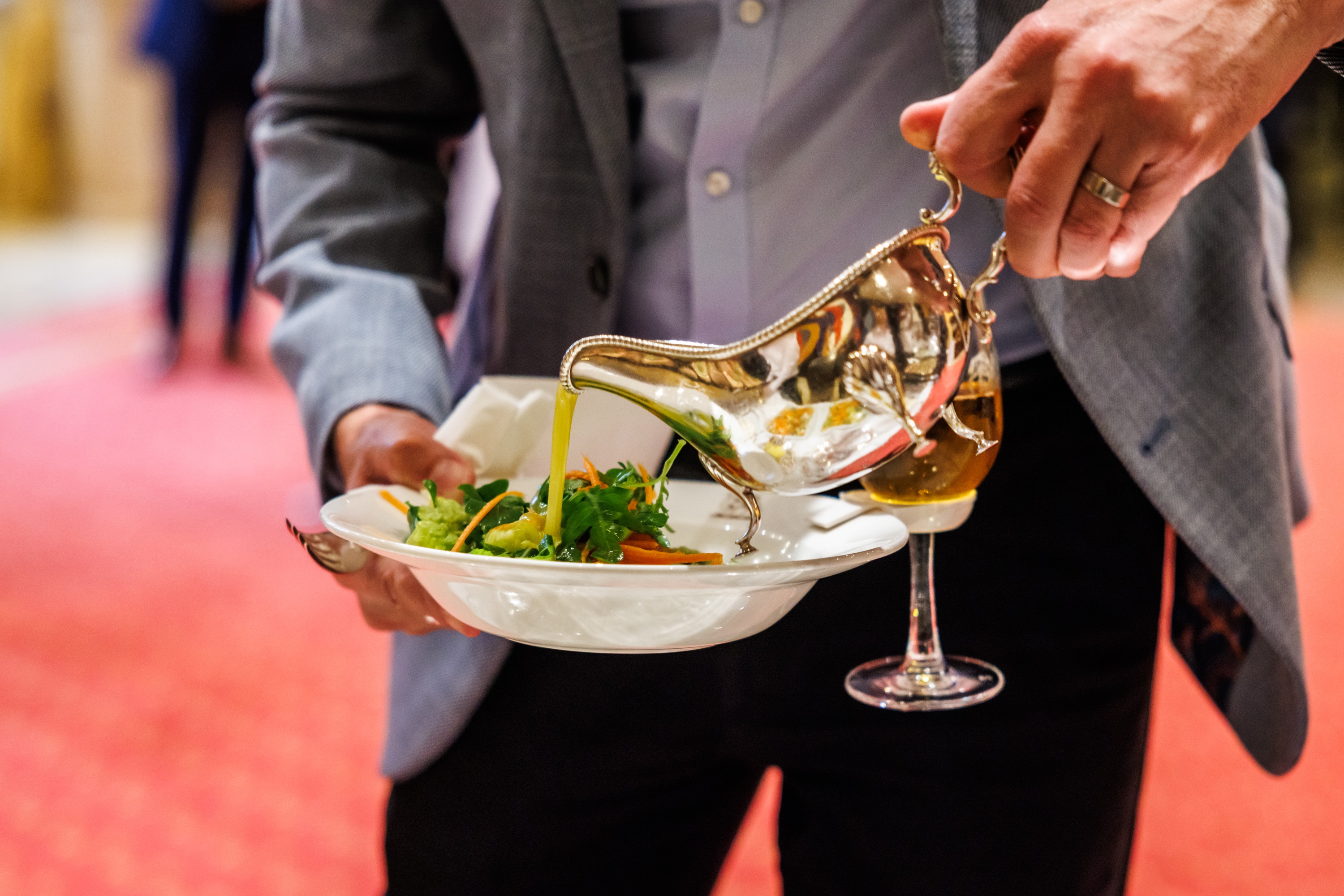 Professional serving a plated dish in elegant Livery Hall, perfect for upscale events.