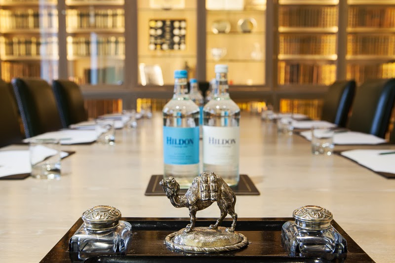 Pitt Library meeting room with polished table, camel figurine, and elegant decor.