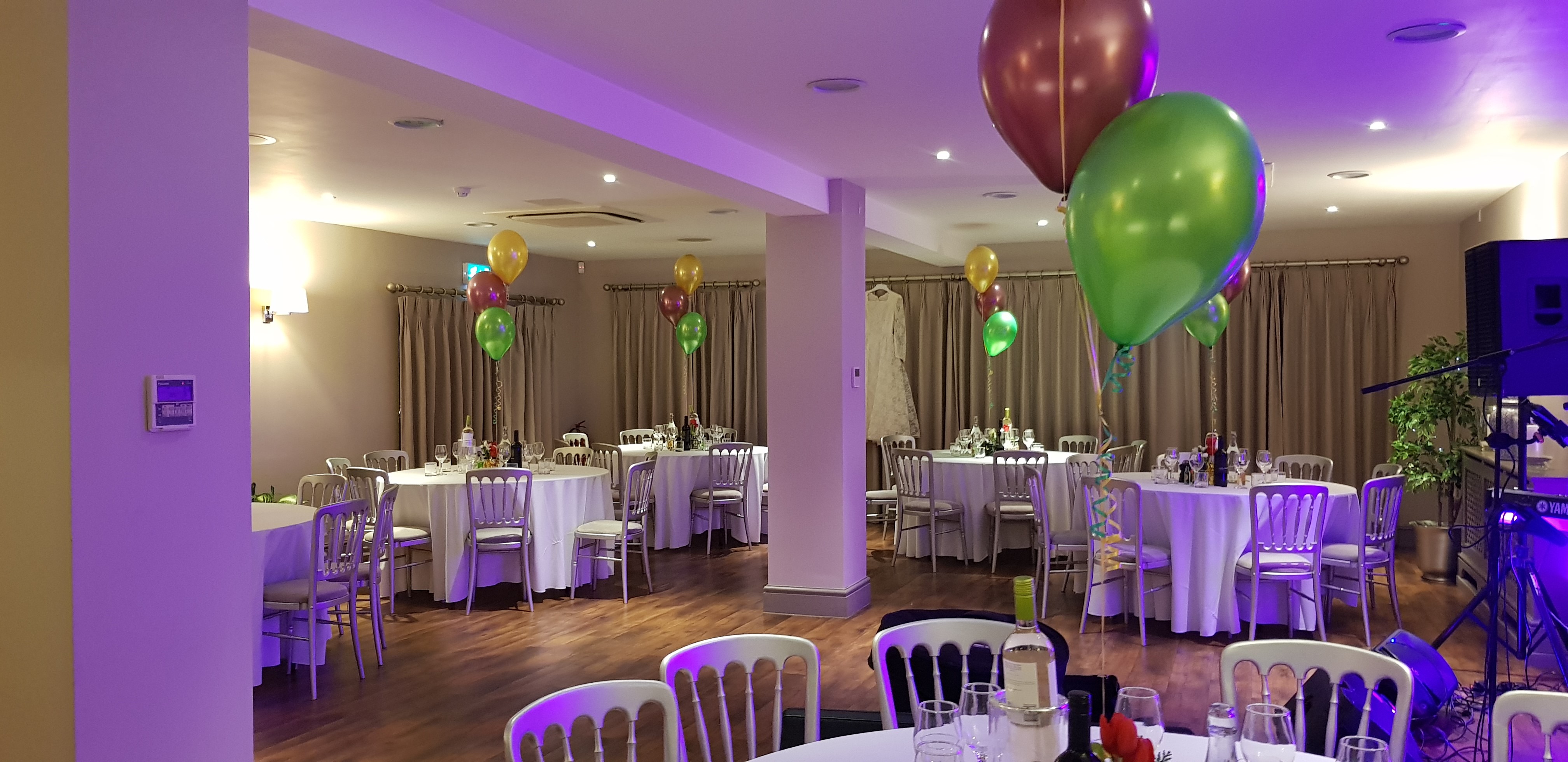 Elegant event space at Blacknest Golf Club with round tables and festive balloons.