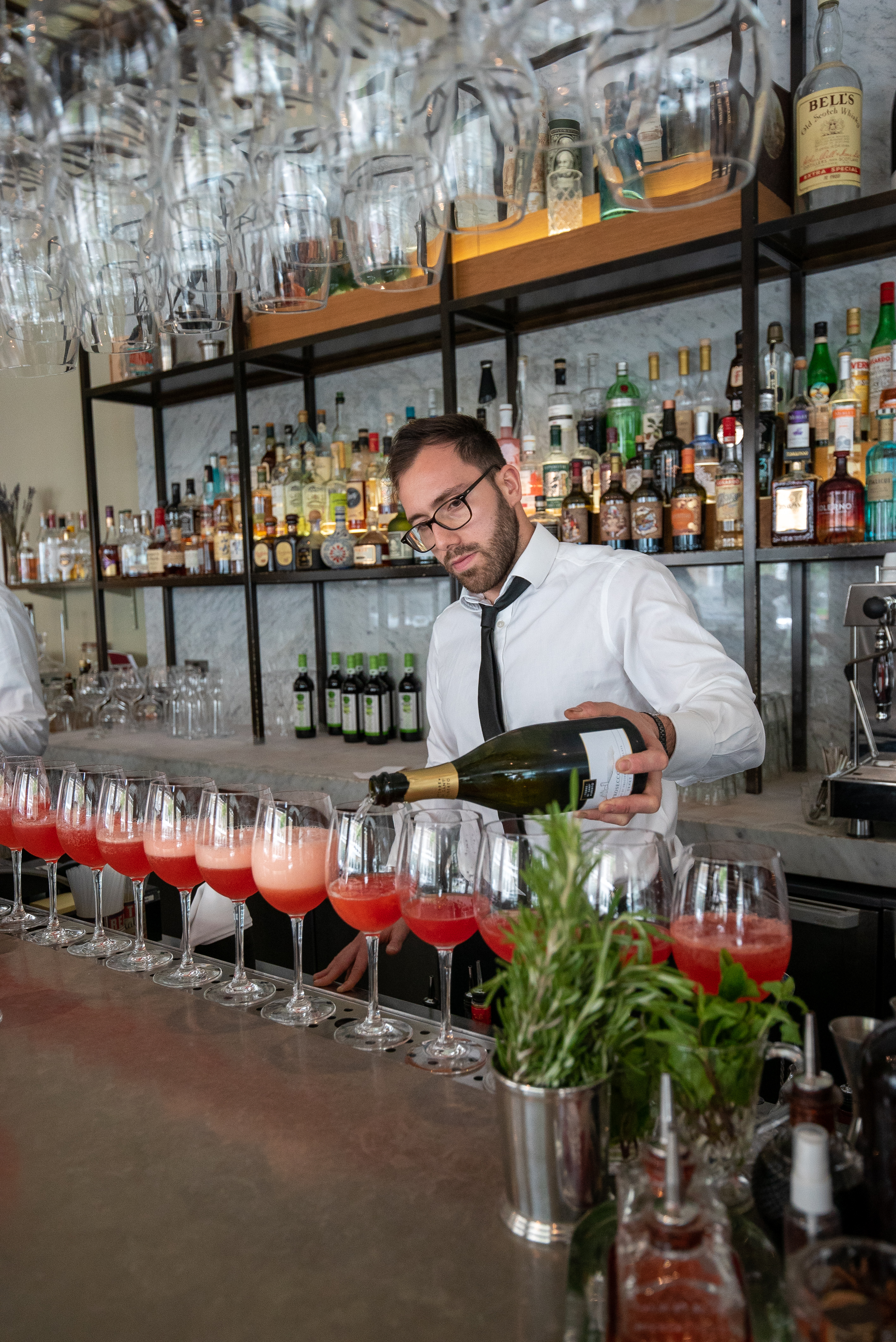 Semi-private dining room at TOZI Restaurant, bartender pouring champagne for upscale events.
