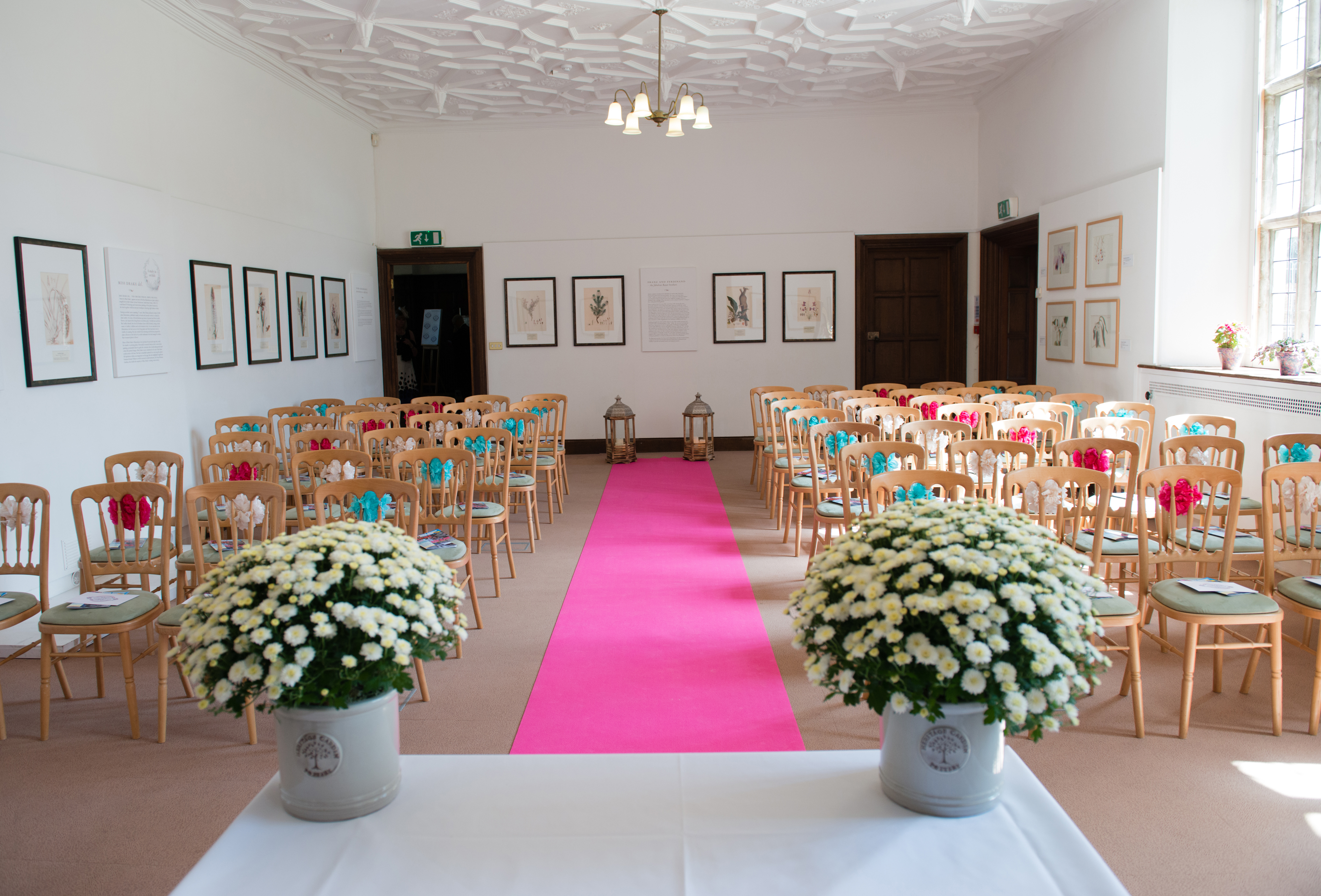 Mansion Gallery event space with wooden chairs and pink aisle runner for ceremonies.