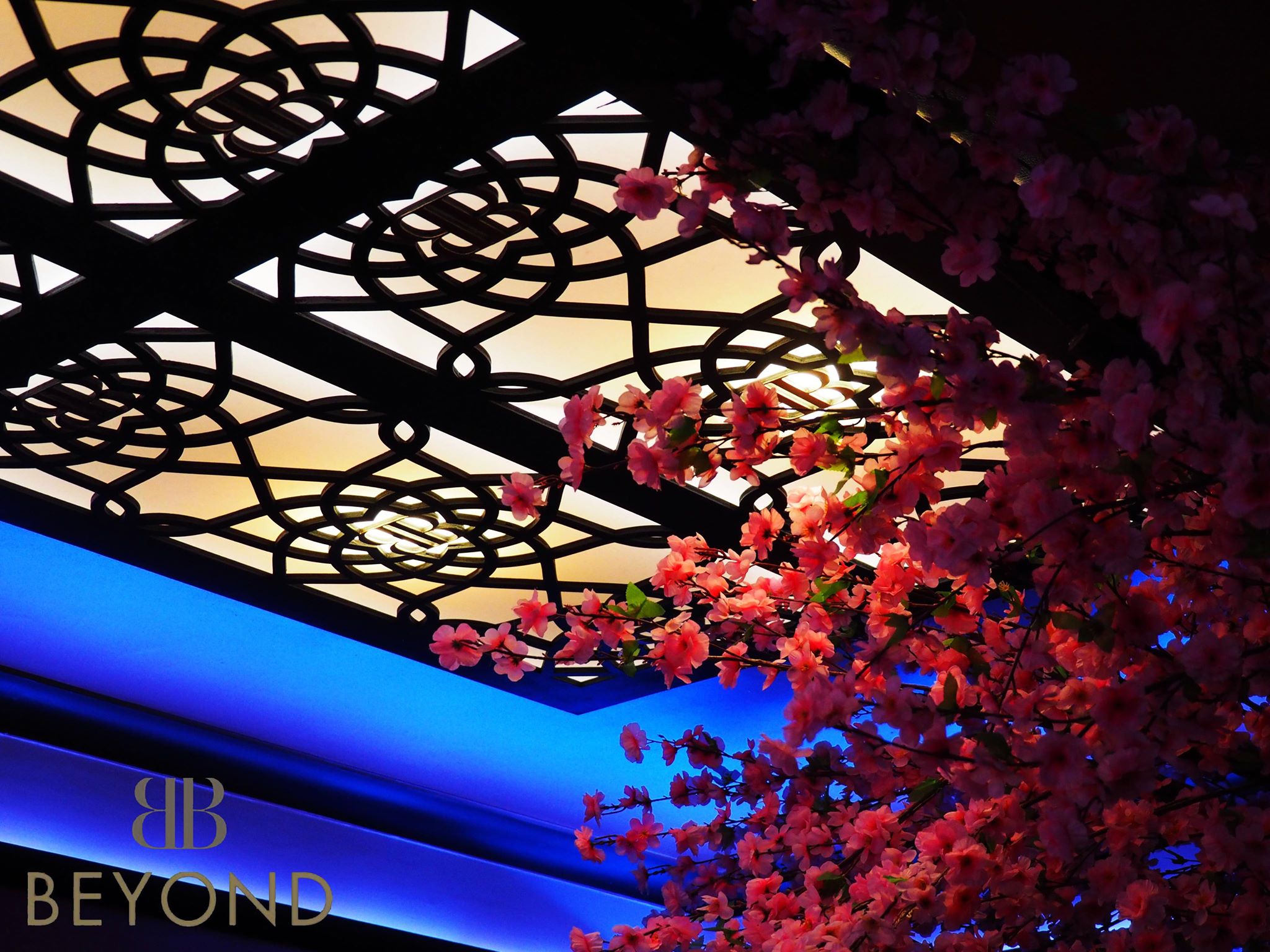 Elegant event space in Bar Beyond with intricate ceiling designs and vibrant floral arrangements.