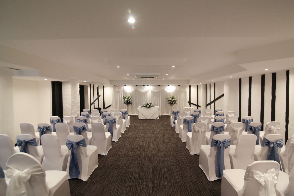 Riverhead Suite at Donnington Manor Hotel, elegant wedding venue with blue-sashed chairs.