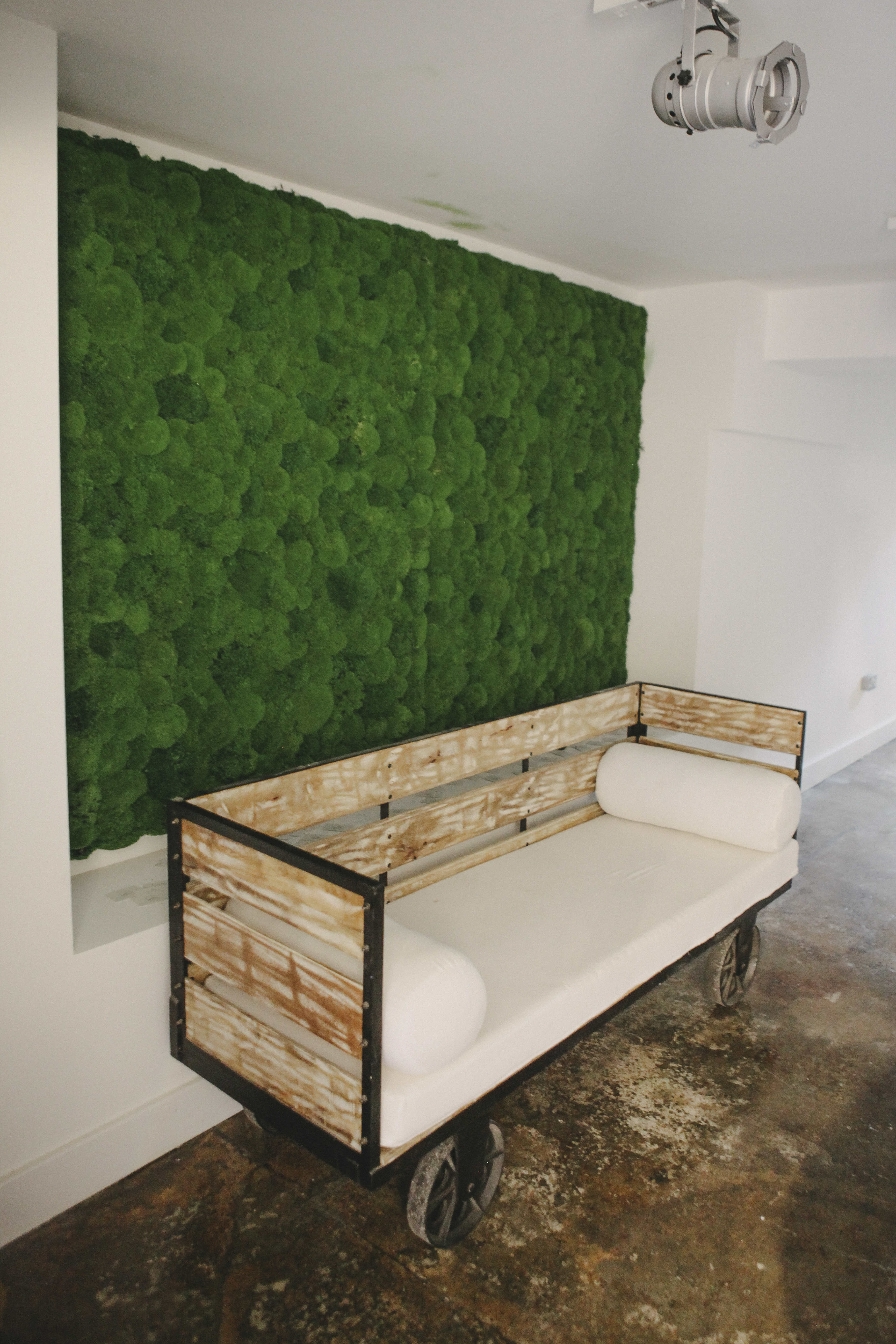 Cafe Broadway Market seating area with rustic bench and moss wall, perfect for events.