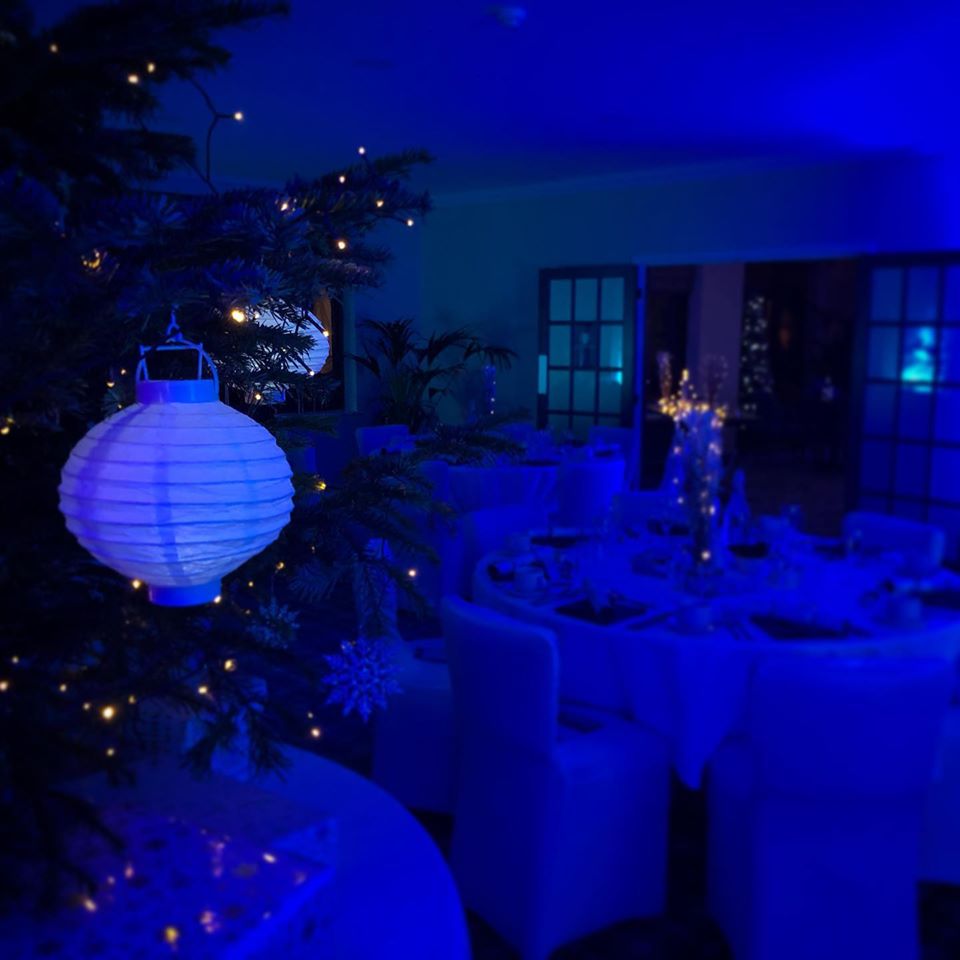 Elegant blue-lit function room at Pyrford Golf Club for upscale holiday parties.