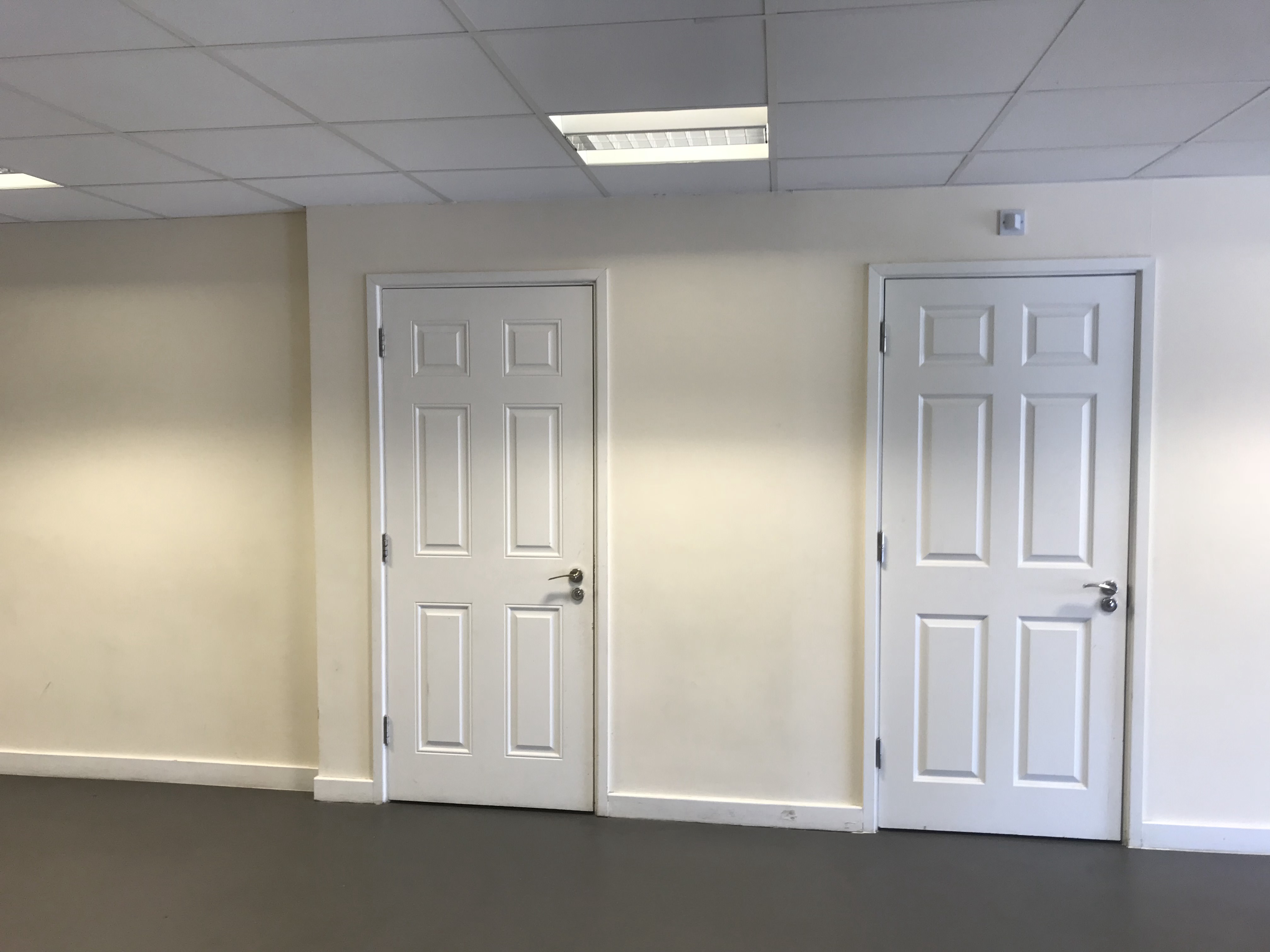 Main Hall in Savoy Court with blank wall and closed doors, perfect for versatile events.