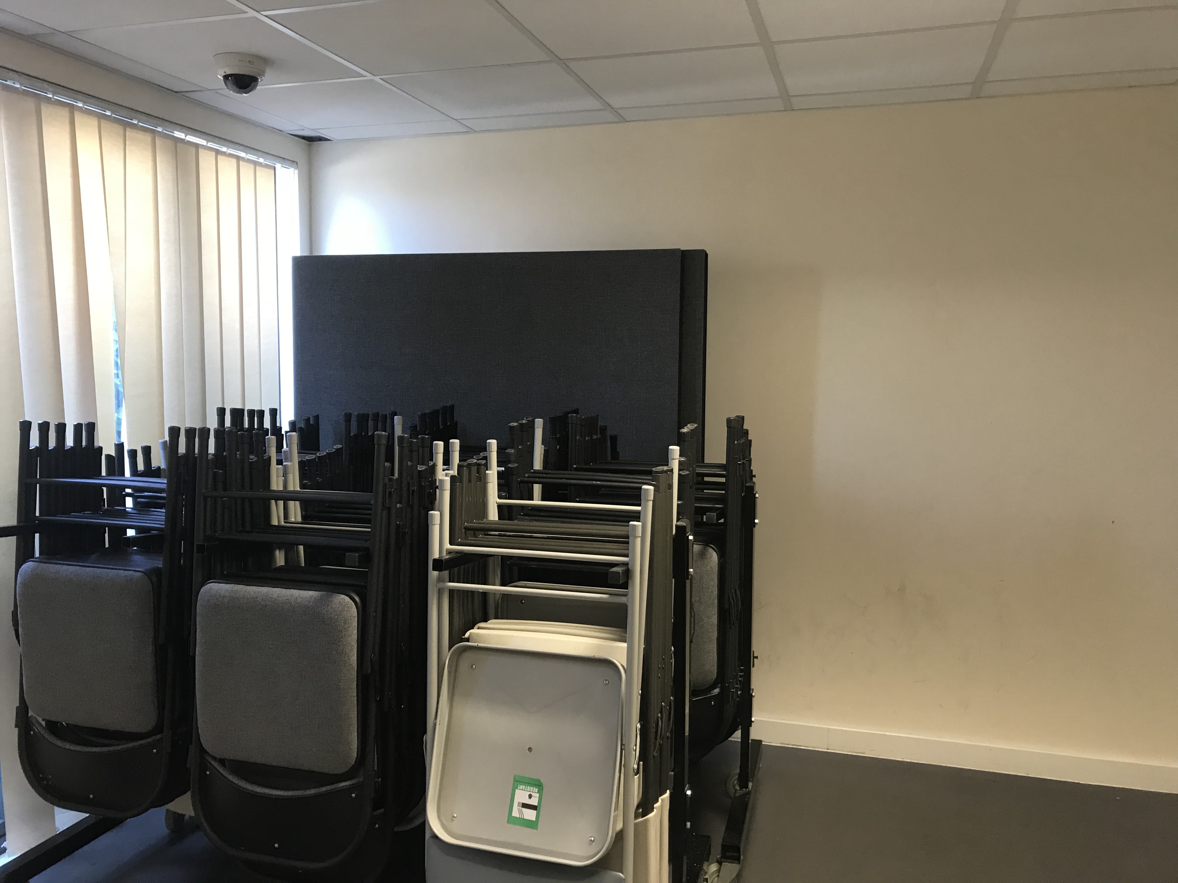 Main Hall in Savoy Court with stacked chairs, ideal for events and meetings.
