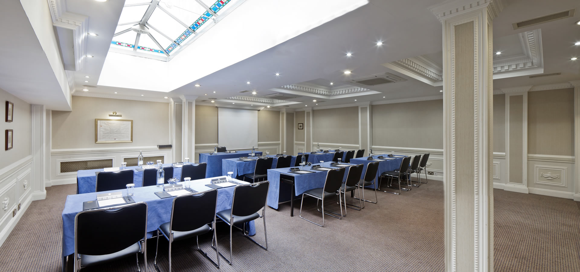 Portland Suite meeting room with blue tablecloths, ideal for workshops and presentations.