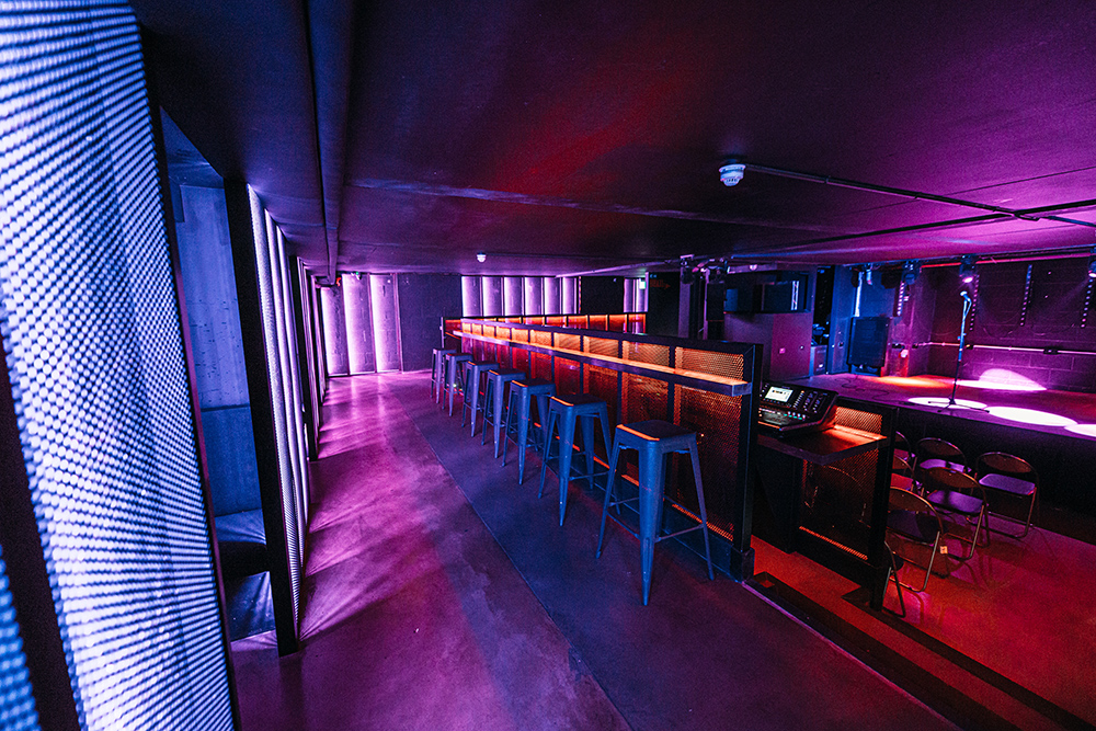 Modern event space with sleek bar and vibrant lighting in Peckham Audio, ideal for gatherings.