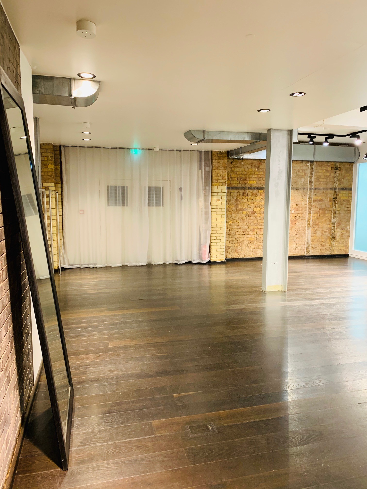 Versatile event space with polished wooden floors in Fitzrovia, ideal for workshops and meetings.