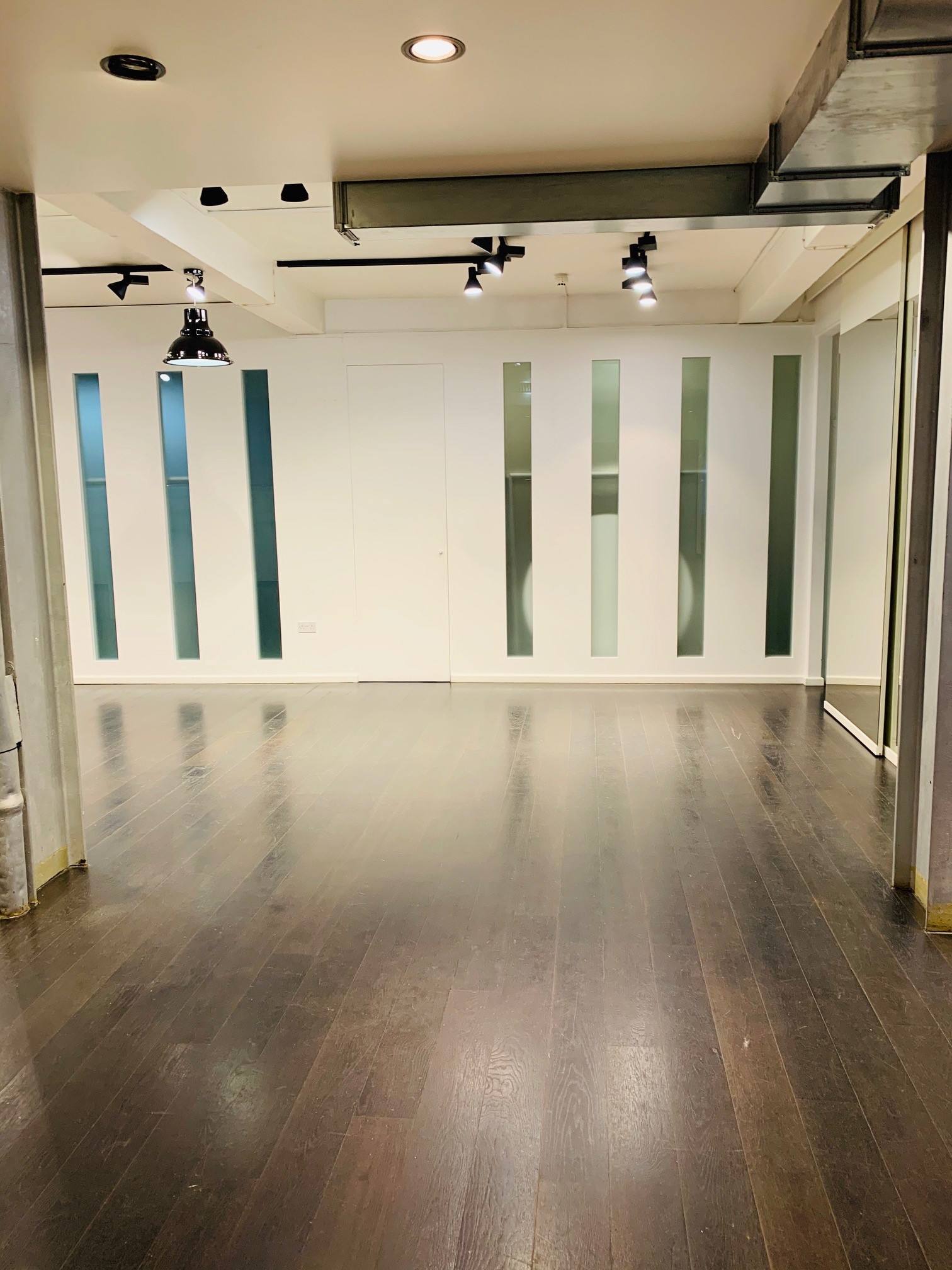 Versatile event space with polished wooden floor in Fitzrovia, ideal for meetings and gatherings.