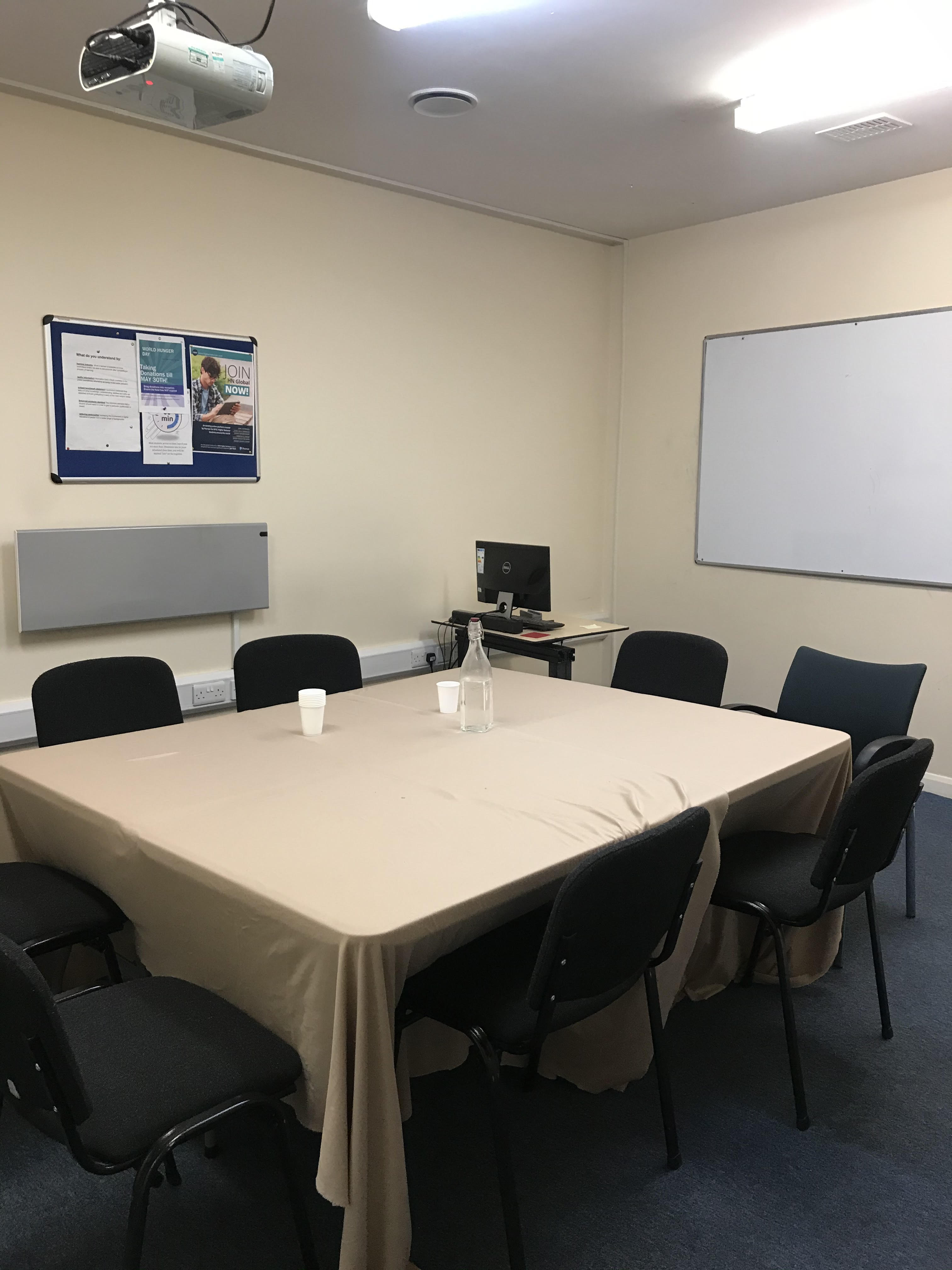 Meeting room at Brit College, Limehouse with rectangular table and black chairs.