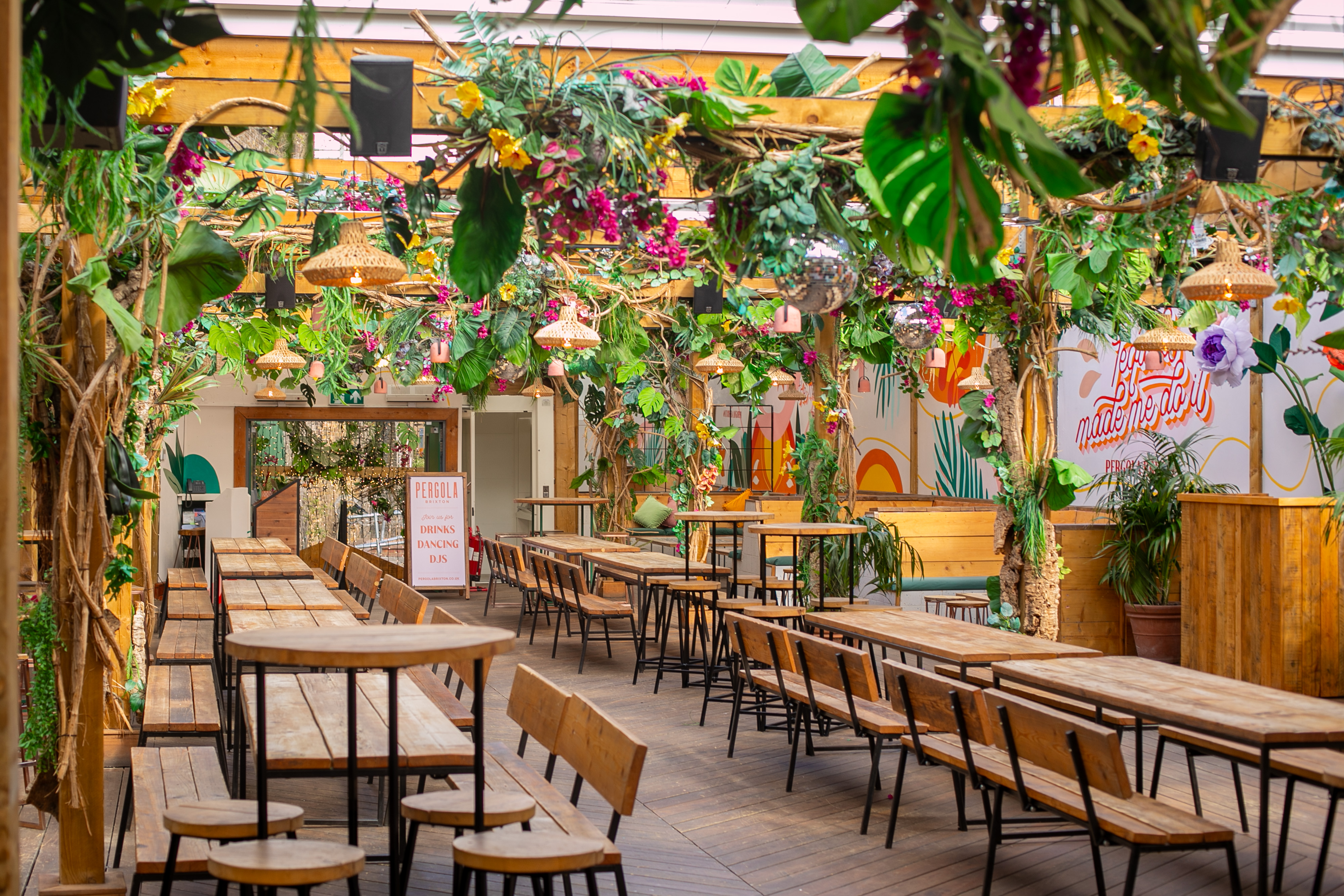 Lush event space at Pergola Brixton with greenery, ideal for gatherings and workshops.
