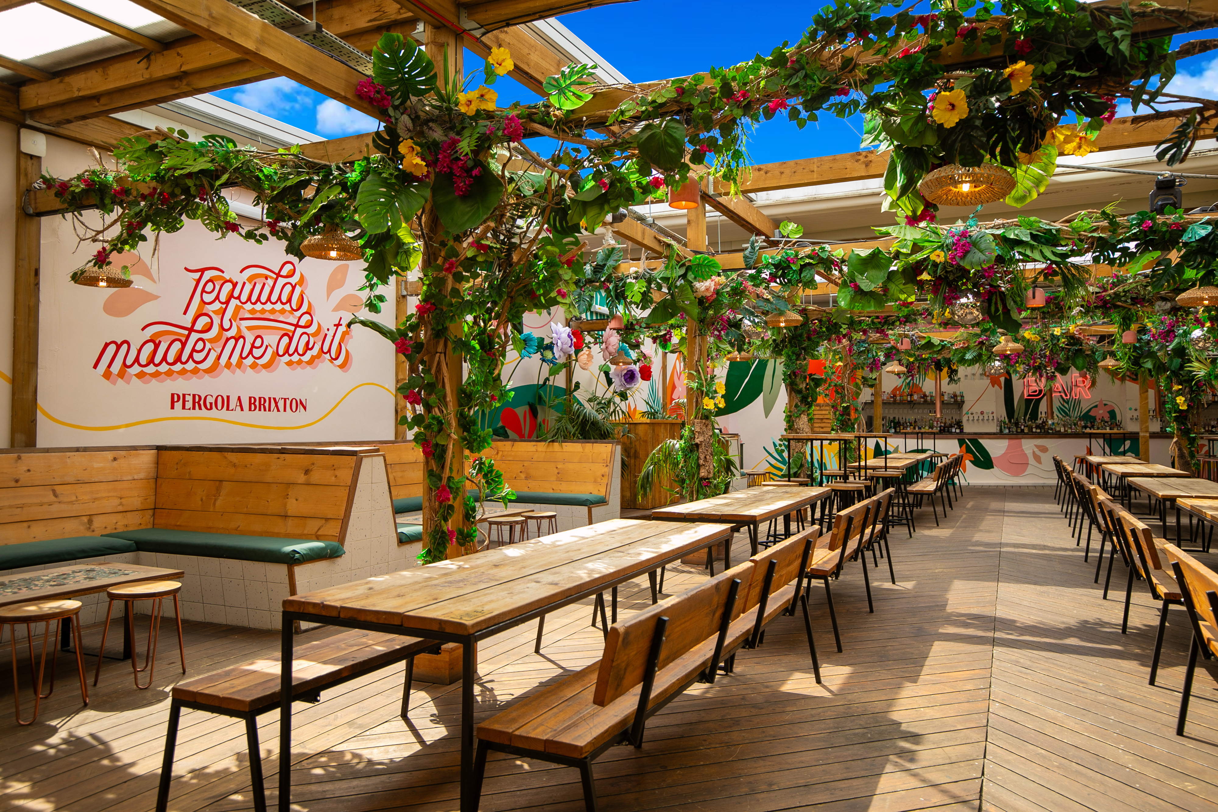 Vibrant outdoor event space at Pergola Brixton with lush greenery and floral decor.