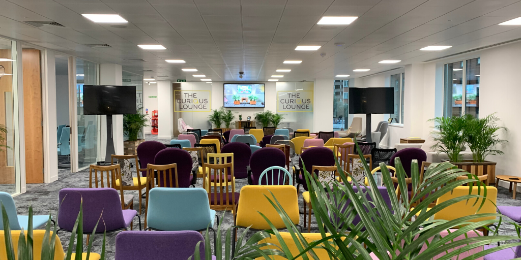 Versatile event space with colorful seating for workshops and meetings in The Curious Lounge.