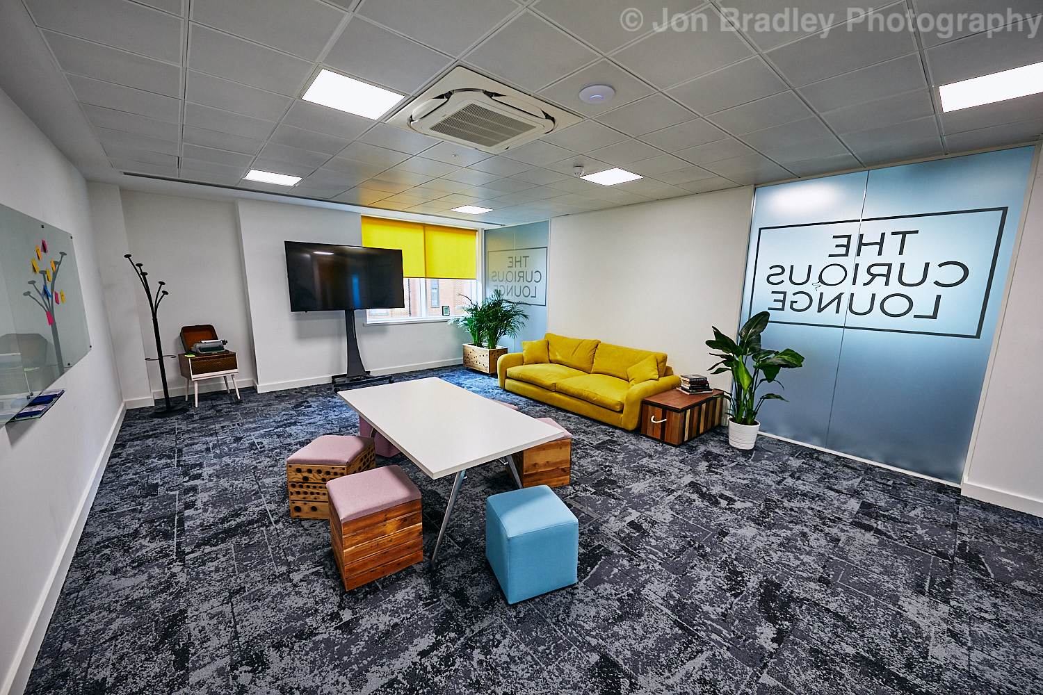 Modern meeting space with bright yellow sofa, ideal for brainstorming sessions.