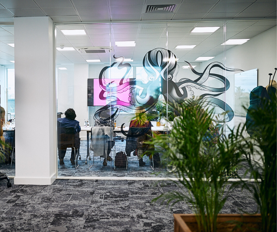 Modern meeting space with glass wall, ideal for creative workshops and brainstorming sessions.