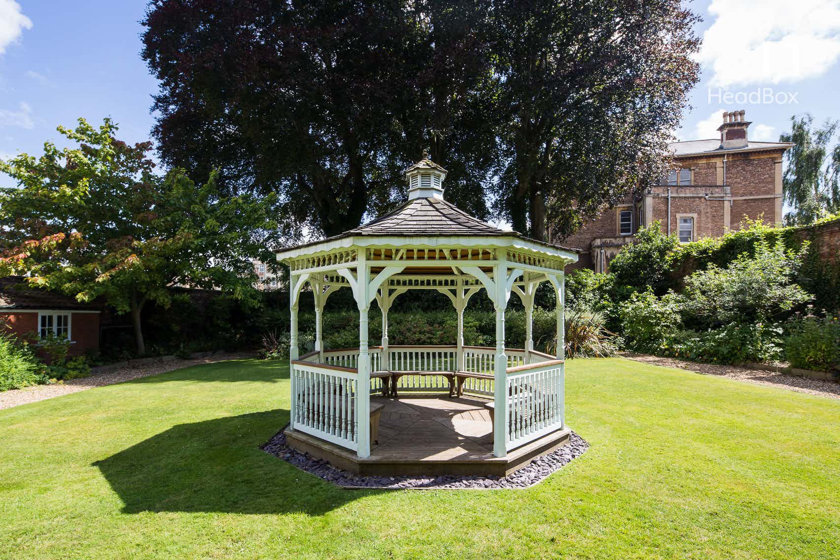 Charming gazebo in lush garden, perfect for outdoor weddings and events.