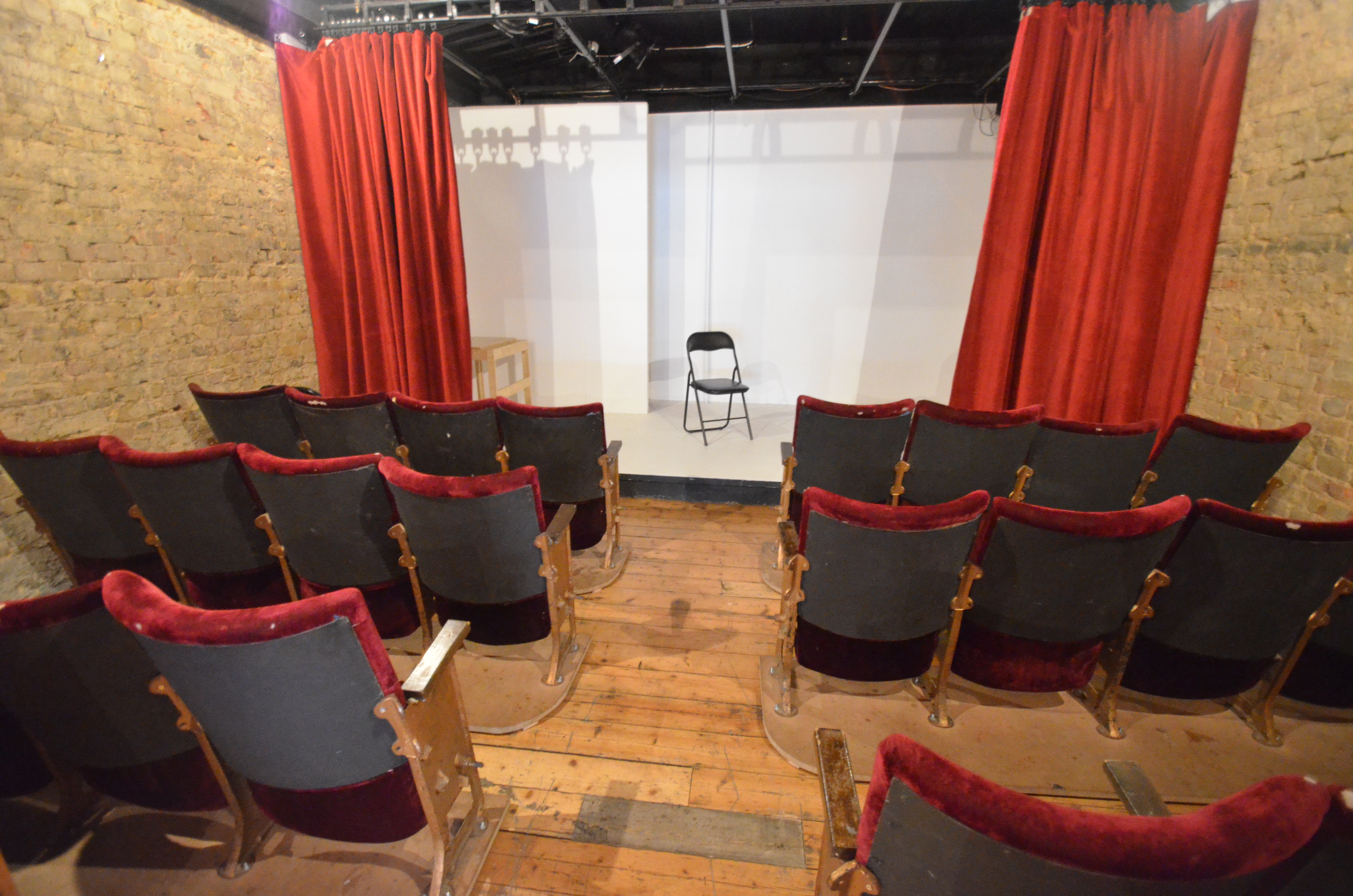 Intimate theater setup with red curtains for workshops and presentations at Calder Theatre.