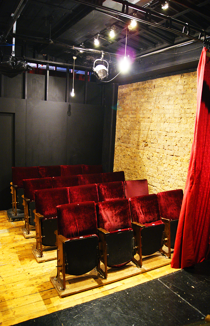 Intimate theater space with plush red seating for exclusive events and performances.