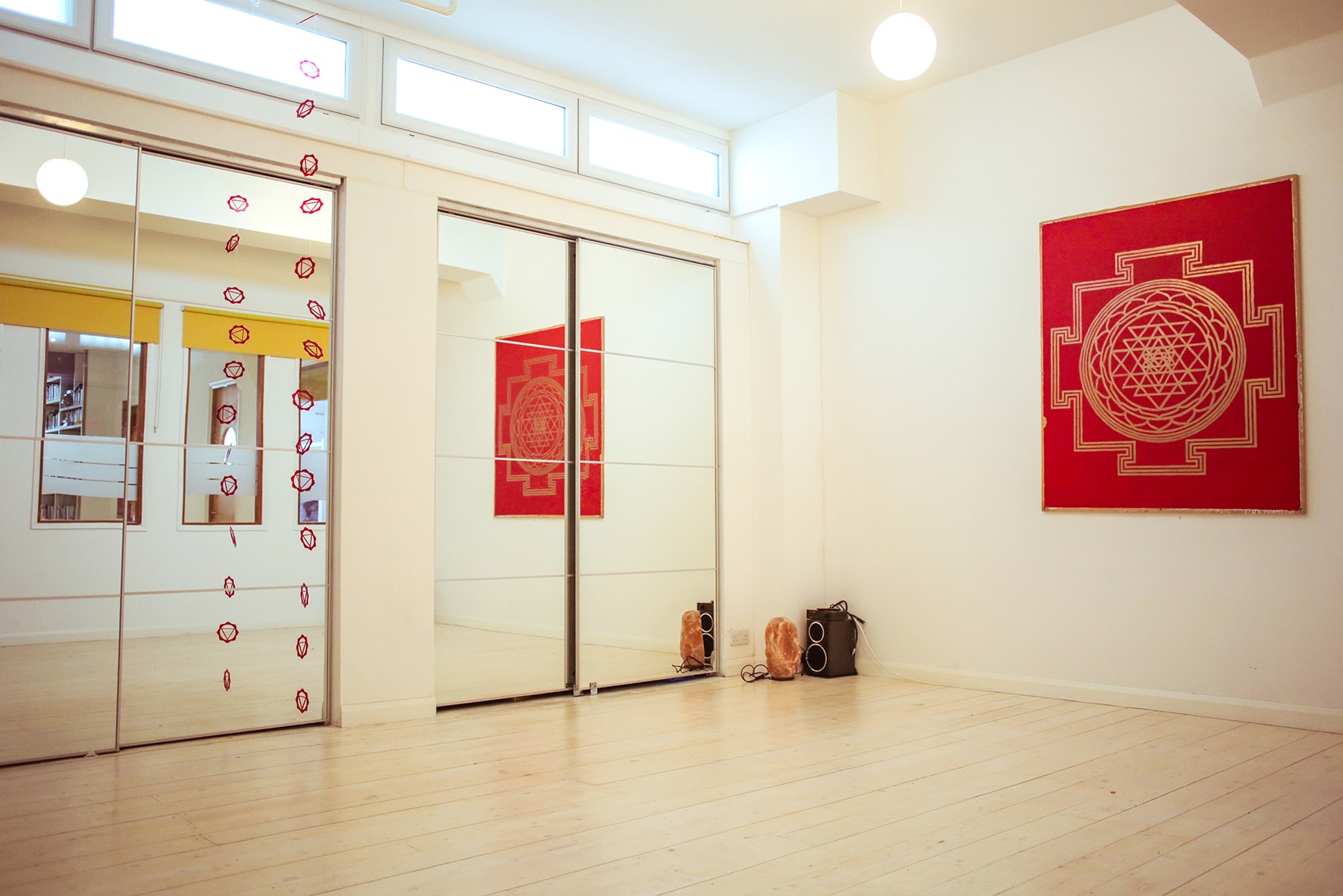 Bright minimalist event space with mirrored walls, perfect for yoga workshops at Tara Yoga Centre.