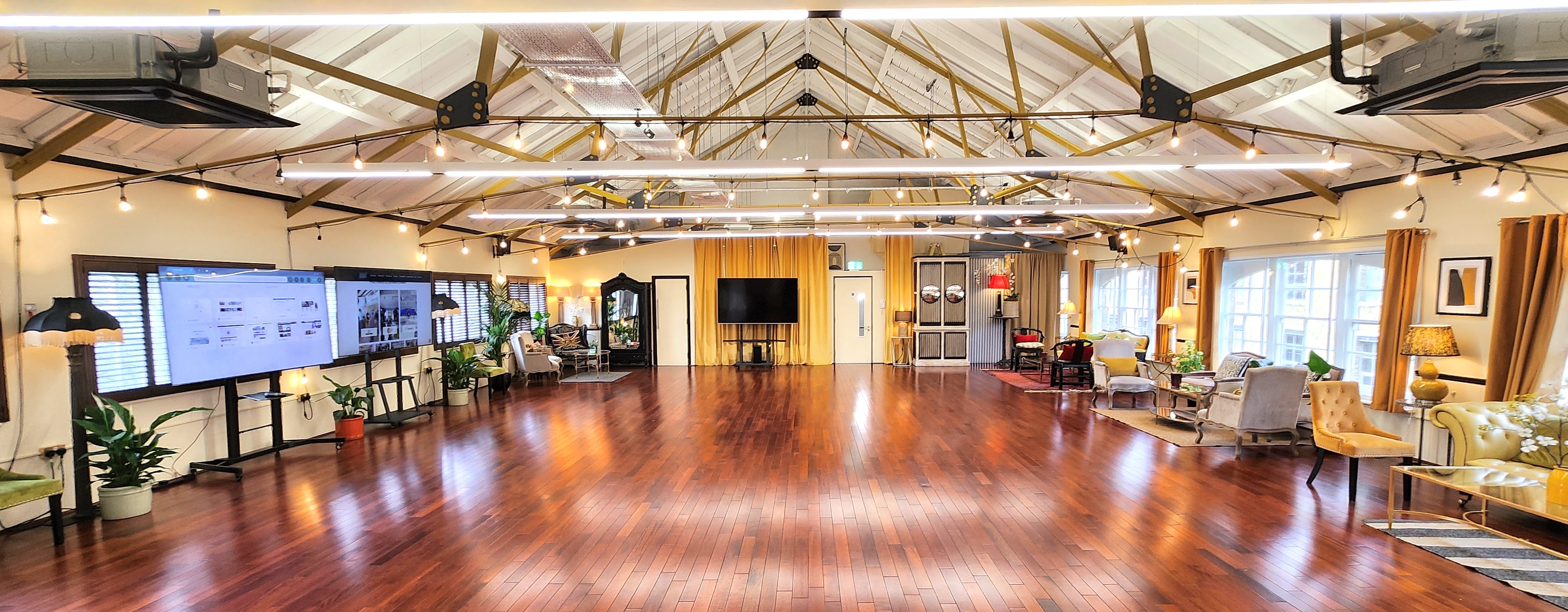 Spacious event space with wooden flooring for corporate events and celebrations.