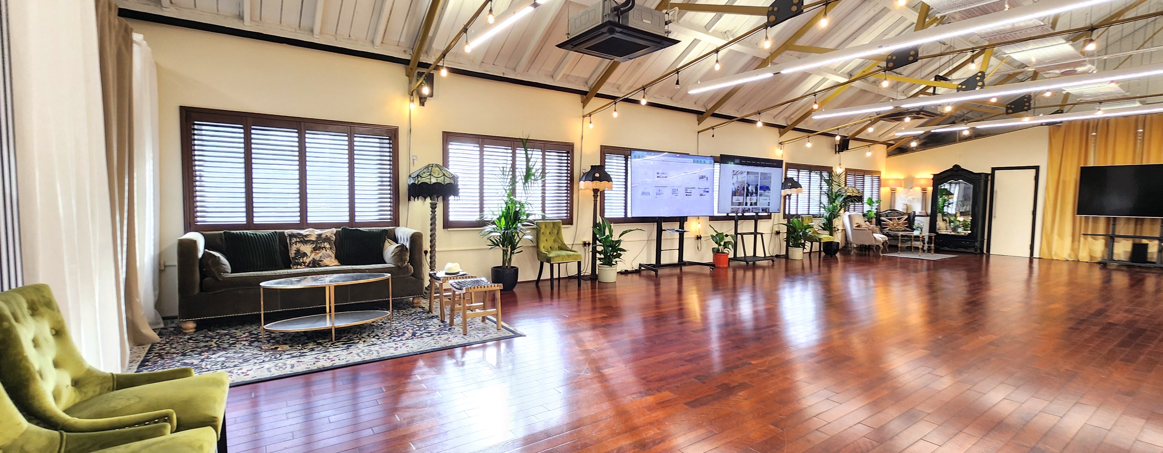Versatile event space with wooden floors and natural light for meetings or gatherings.