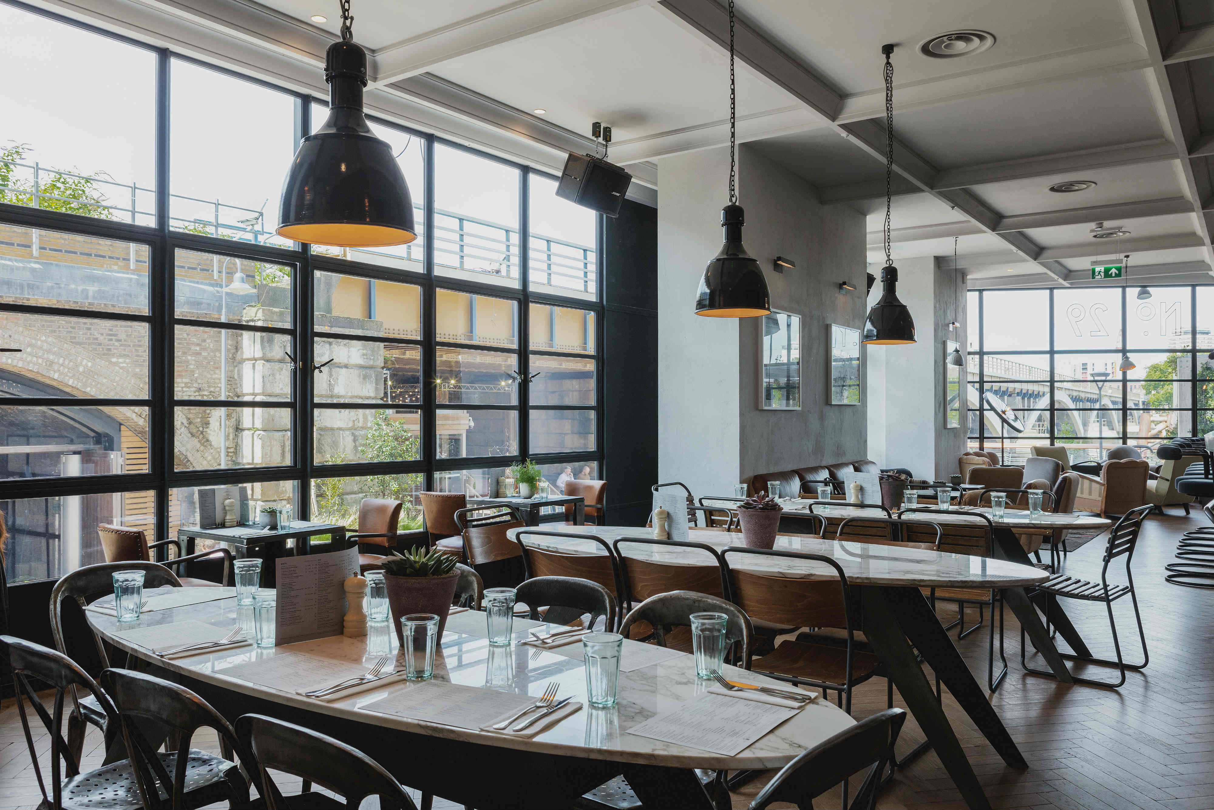 Modern restaurant venue with large windows, ideal for meetings and events.