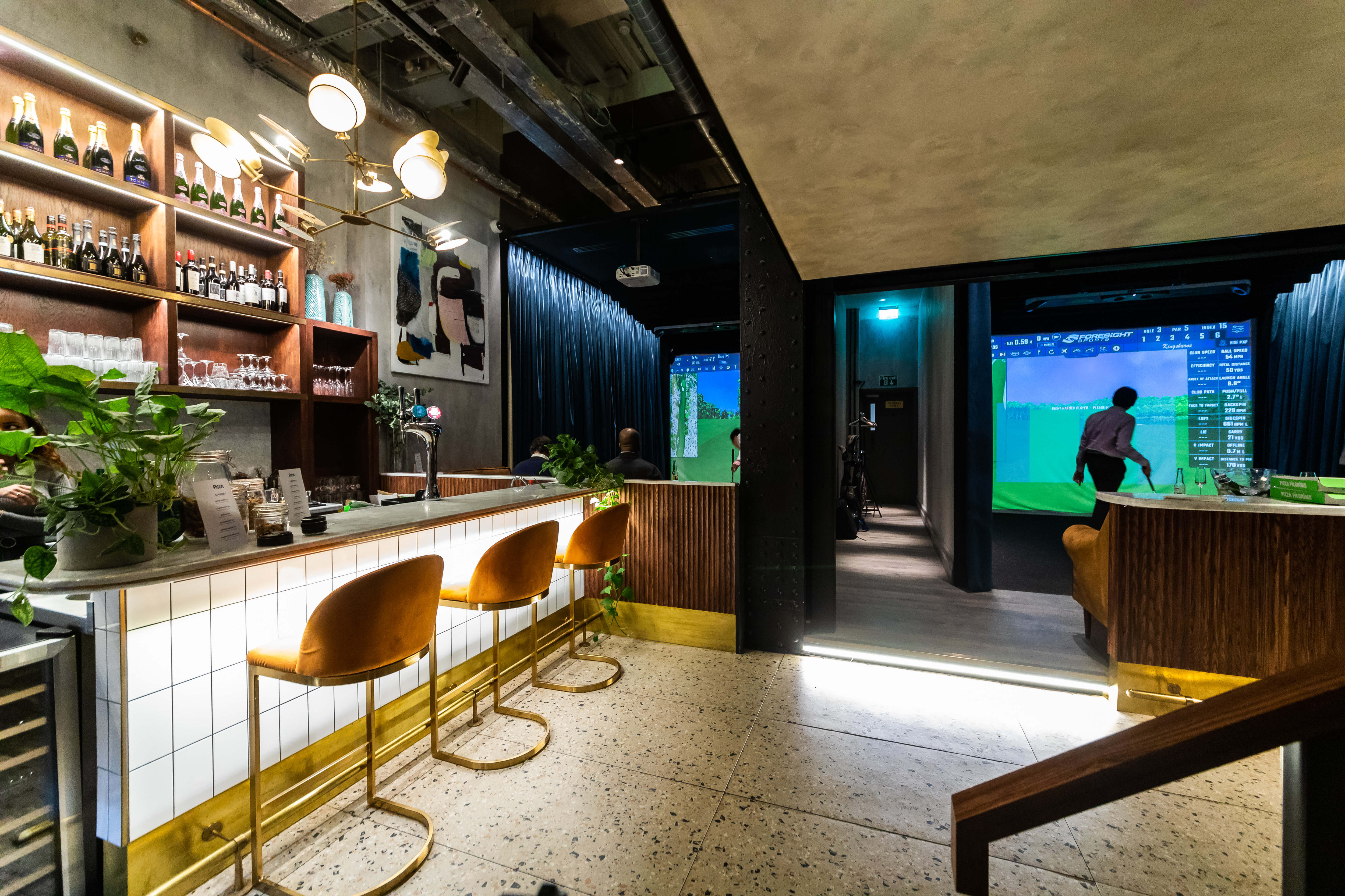 Modern event venue with stylish bar and dual screens for corporate meetings and gatherings.