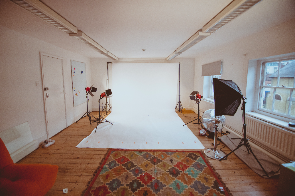 Versatile studio space with white backdrop, ideal for photo shoots and creative events.