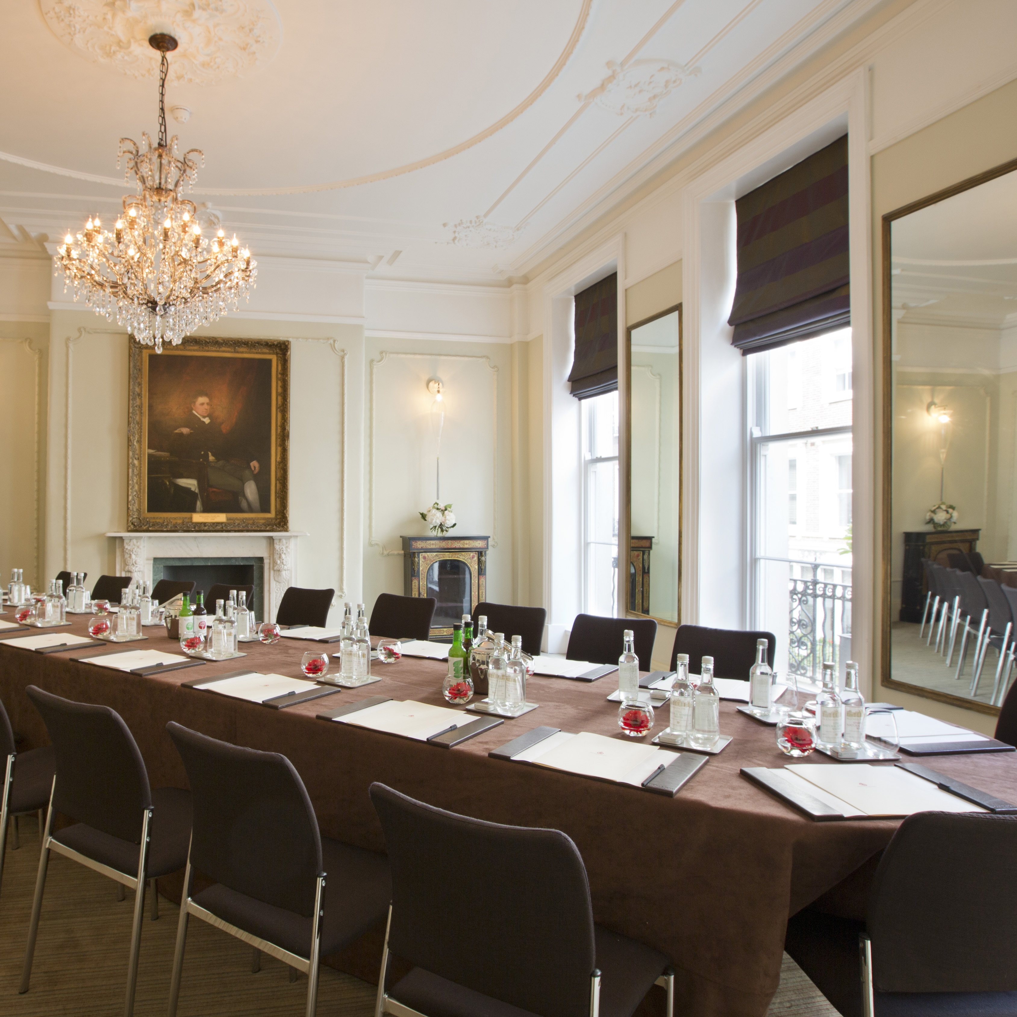Elegant meeting room at Brown's Hotel, featuring chandelier and natural light for conferences.