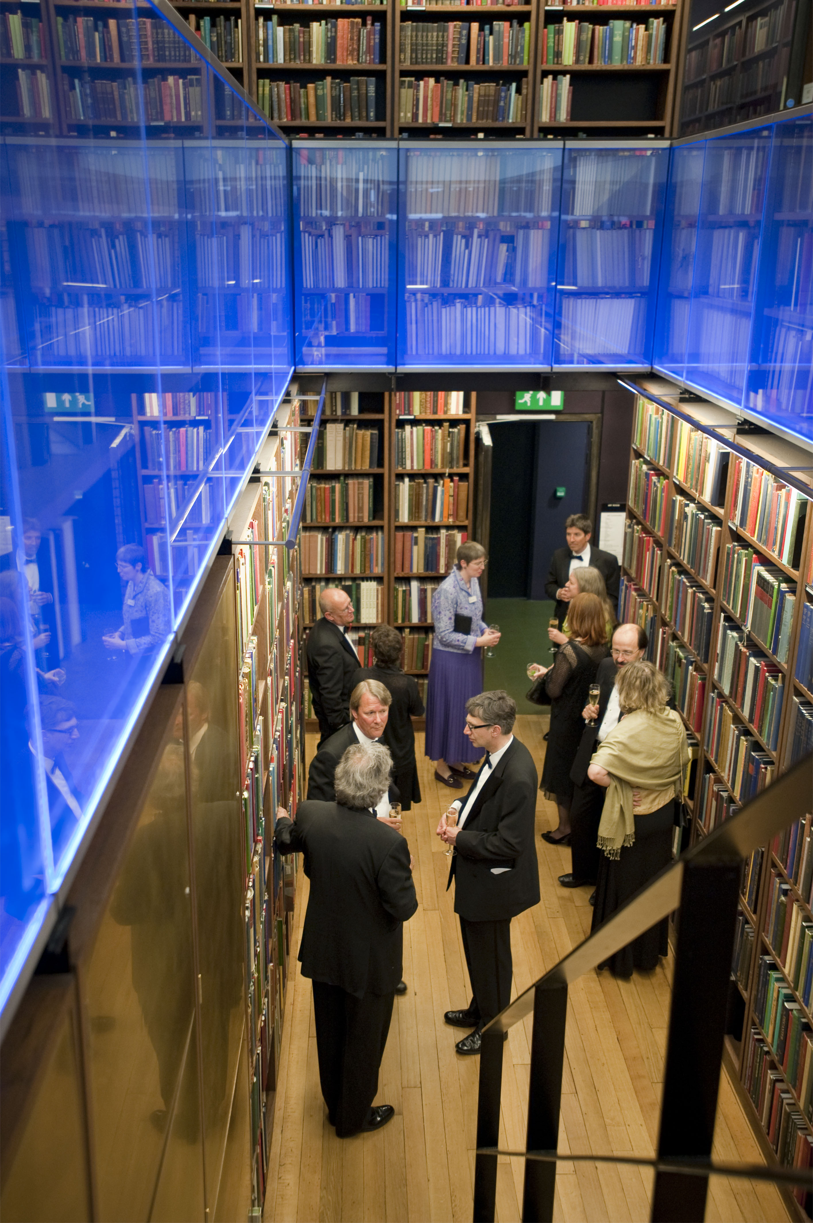 Sophisticated networking event in The London Library with elegant attire and books.